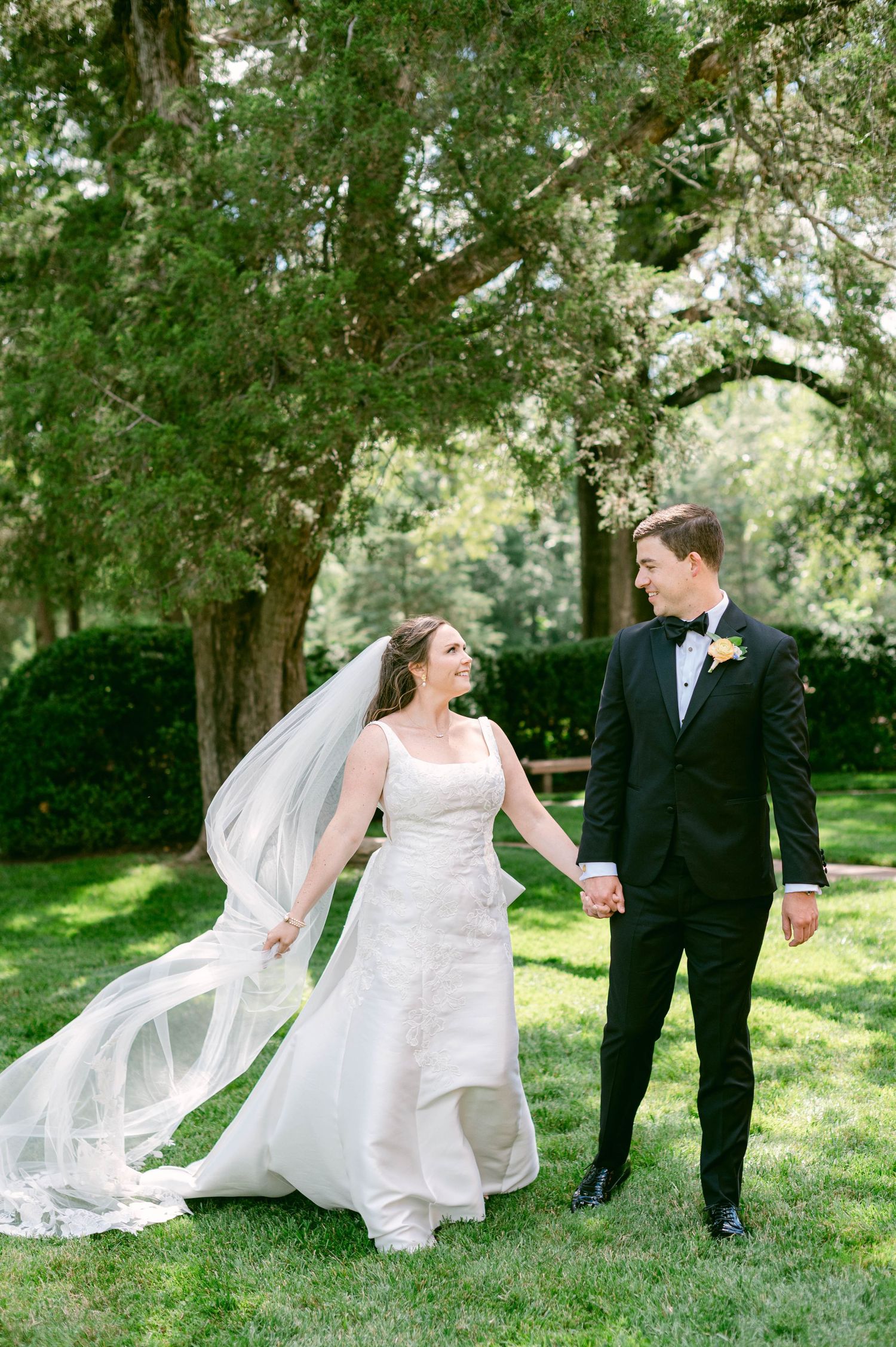 Bride and groom share a joyful moment on their wedding day in a scenic outdoor setting.