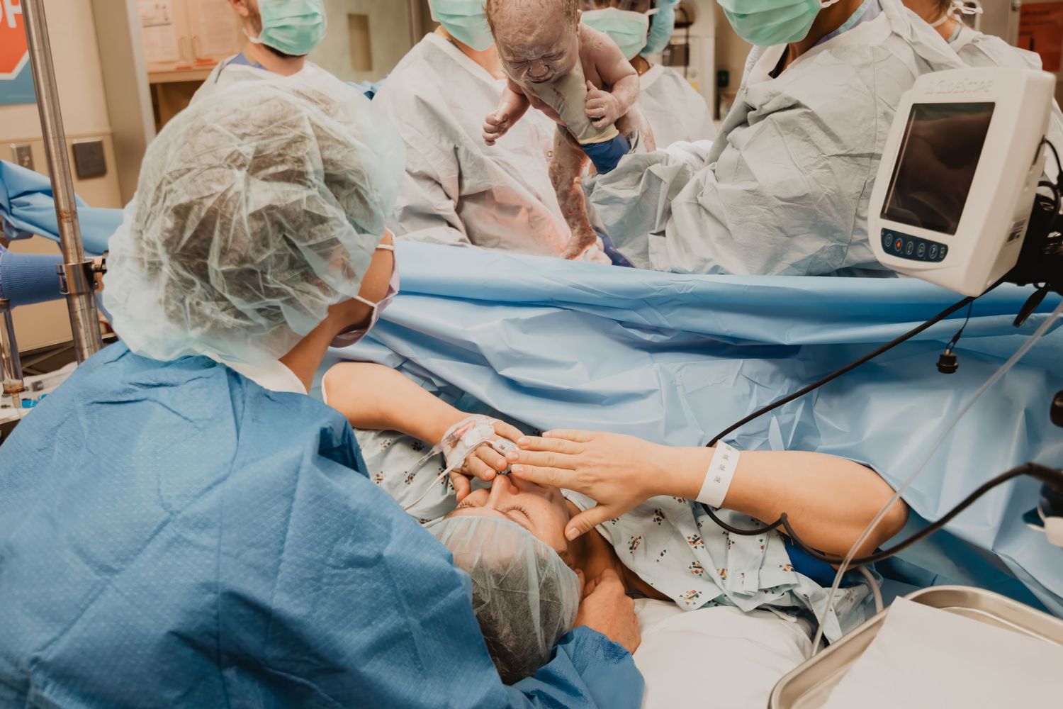 Medical team in protective gear performing surgical procedure in operating room.