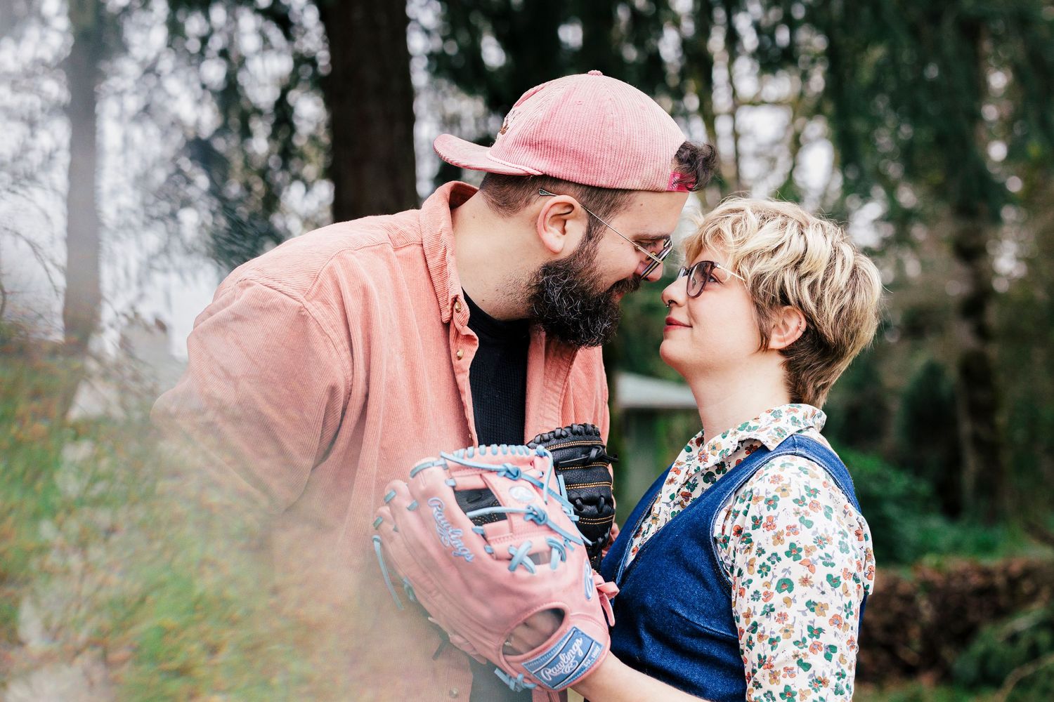 Two people sharing a tender moment outdoors in spring while wearing pink and blue outfits.