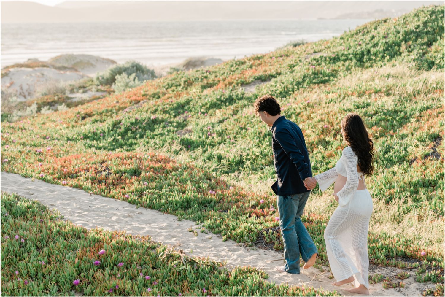 maternity session in Pismo Beach for first time parents walking in the sand dunes along pismo beach