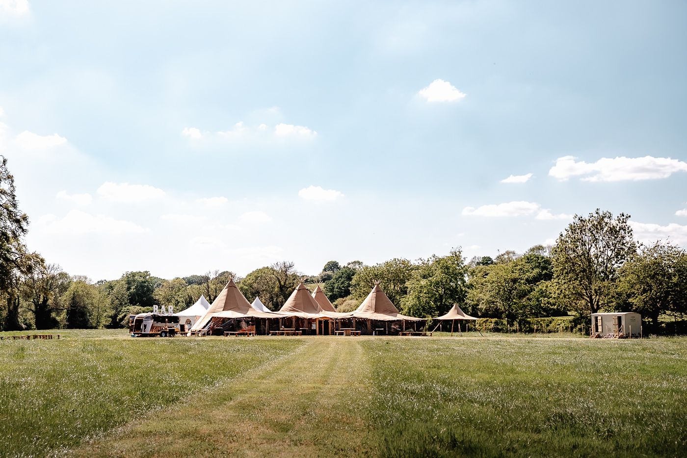 Wedding couple embraces during golden hour in a scenic countryside setting.