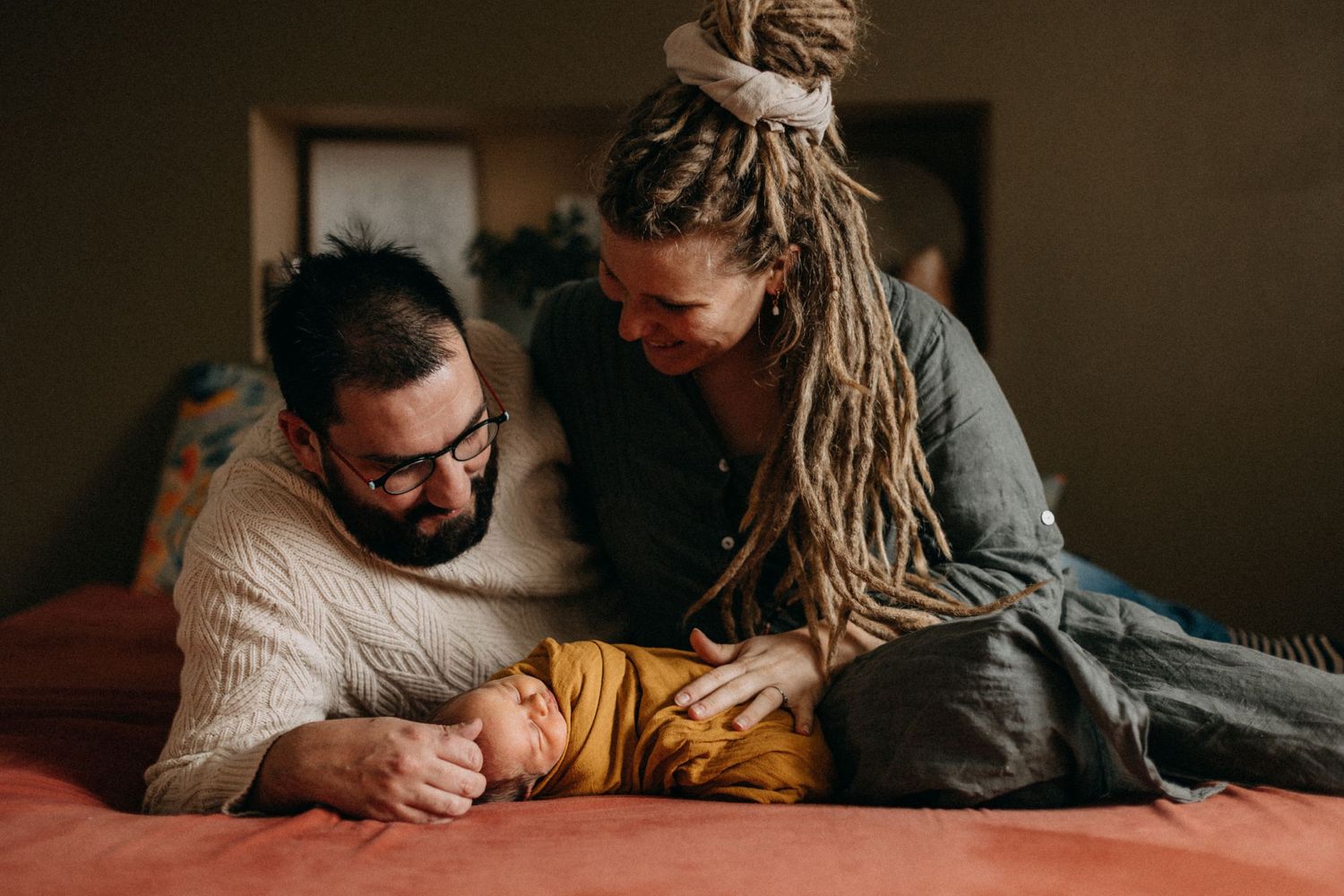 Loving parents sharing tender moment with baby on bed.