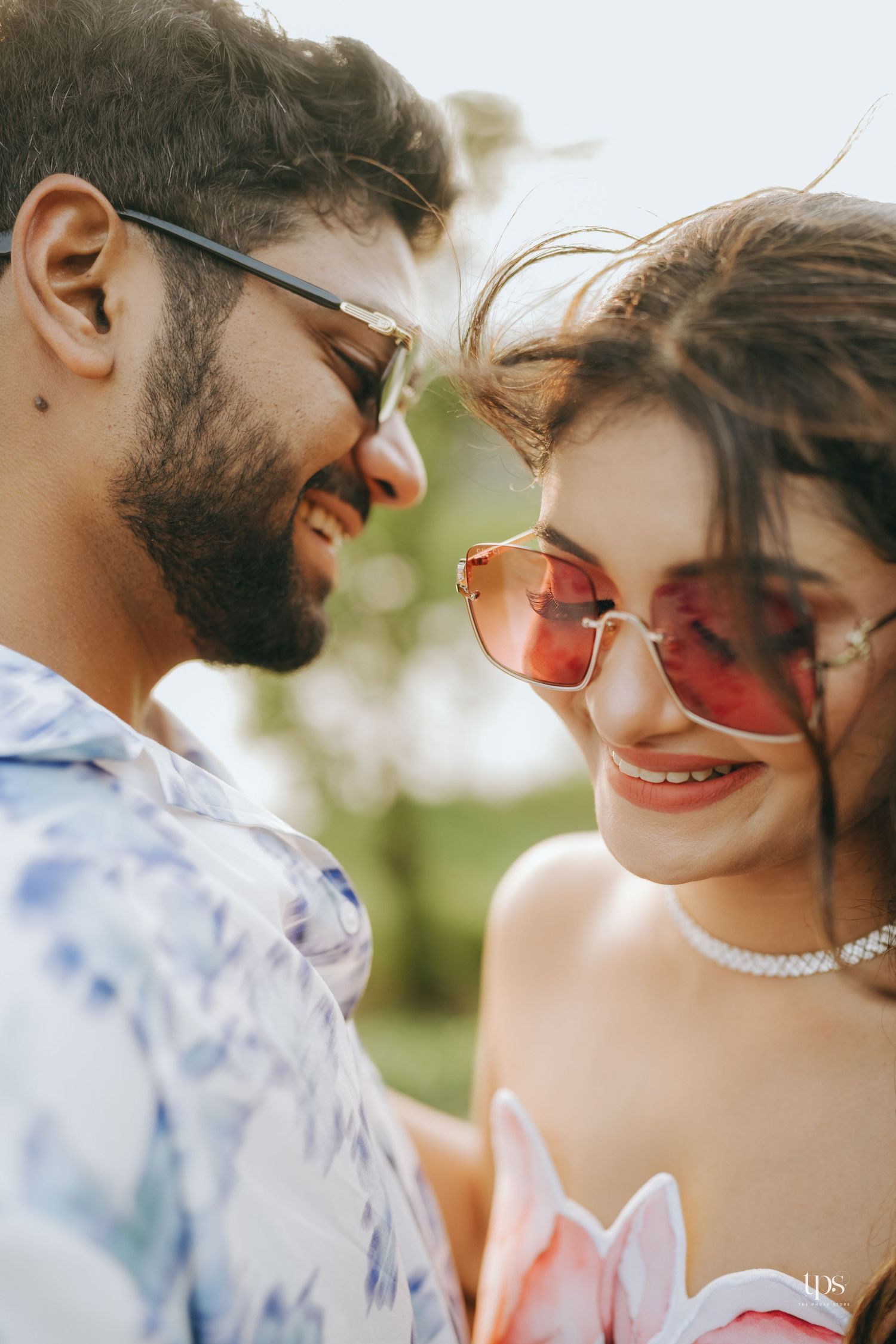 Stylish couple in sunglasses sharing romantic moment outdoors in summer.