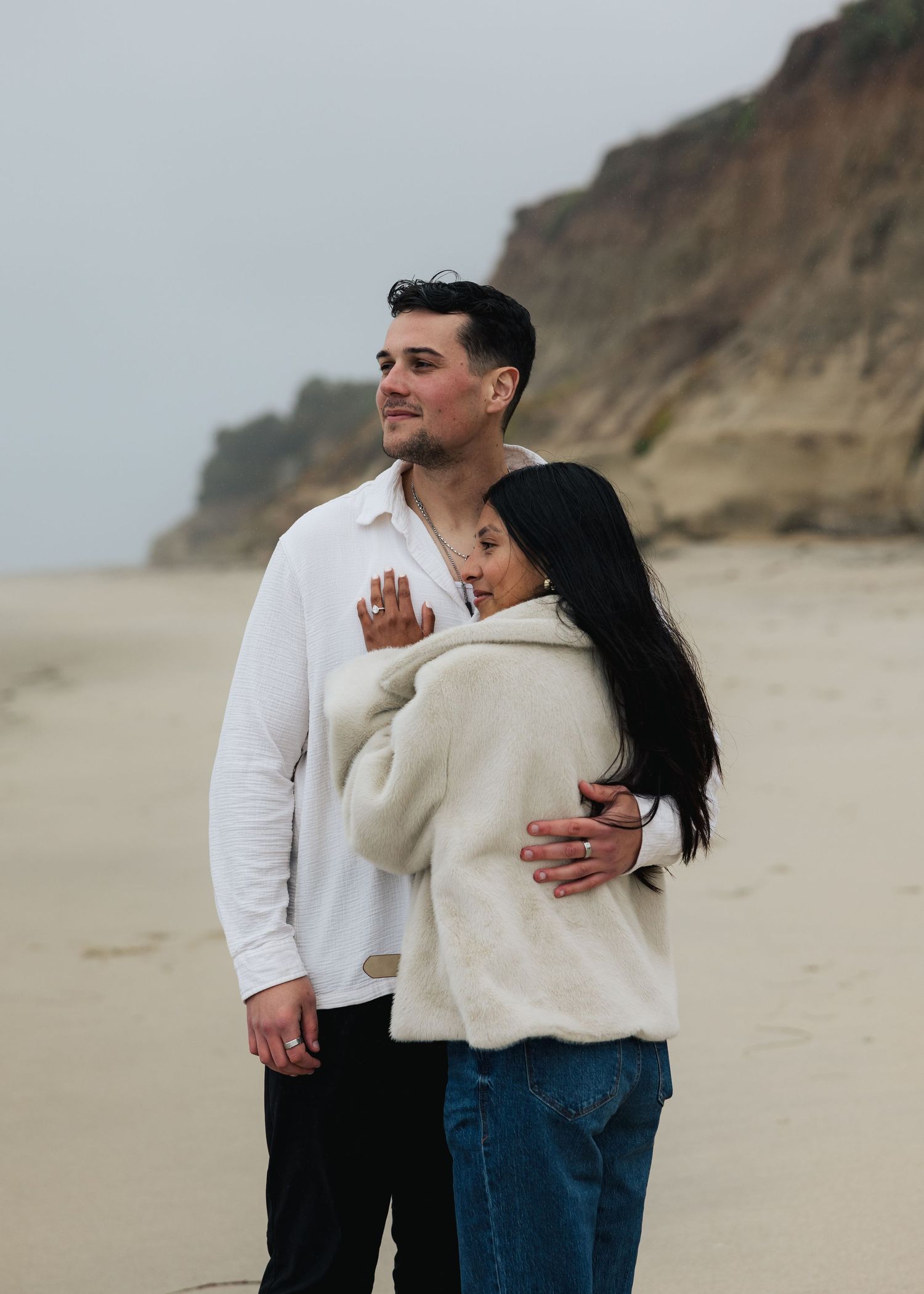 A surprise, coastal proposal in Oceanside, California on a misty evening featuring a surprise party celebration with family and friends