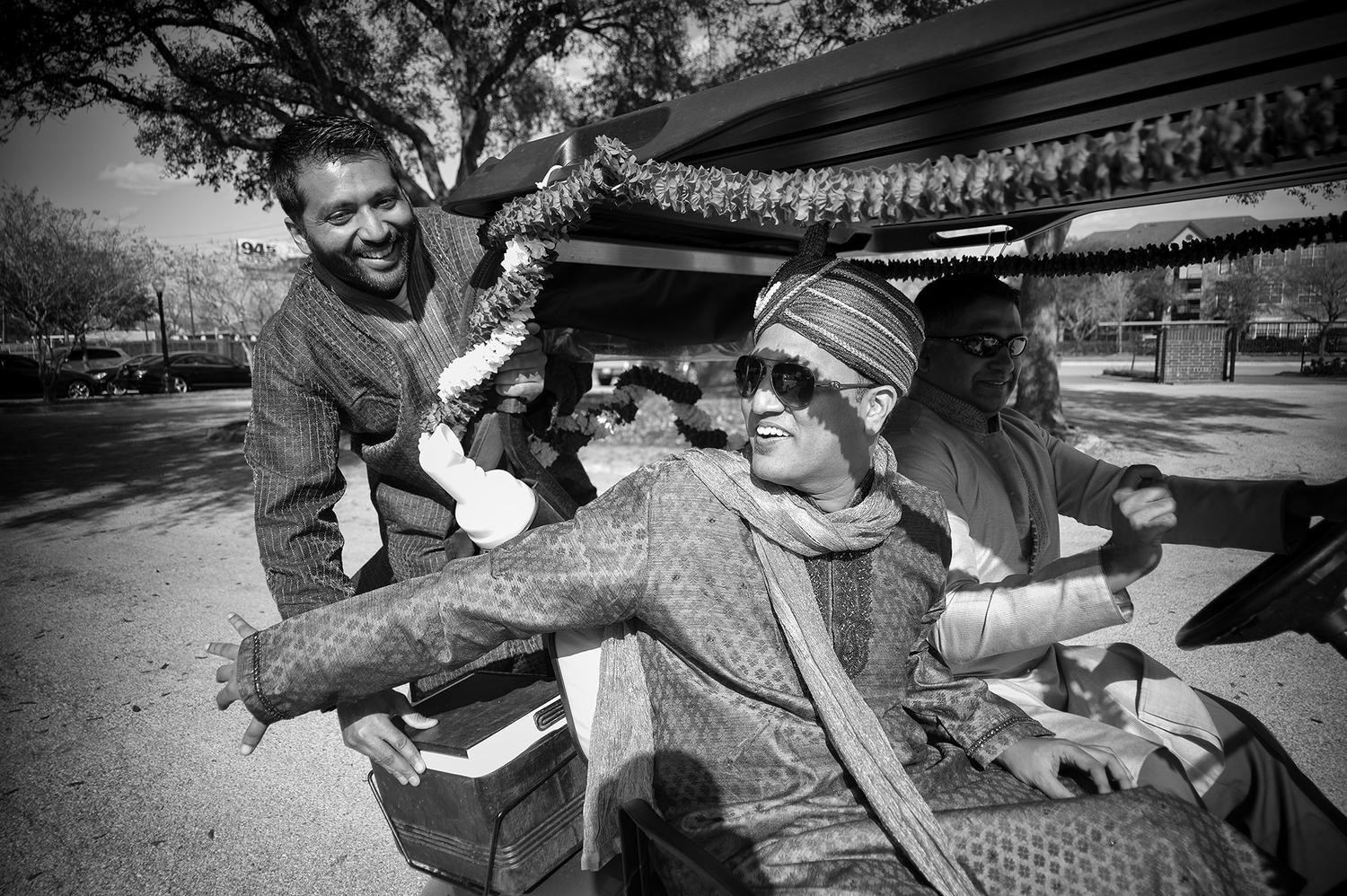 A black and white candid moment of joy and laughter during a casual outdoor gathering.