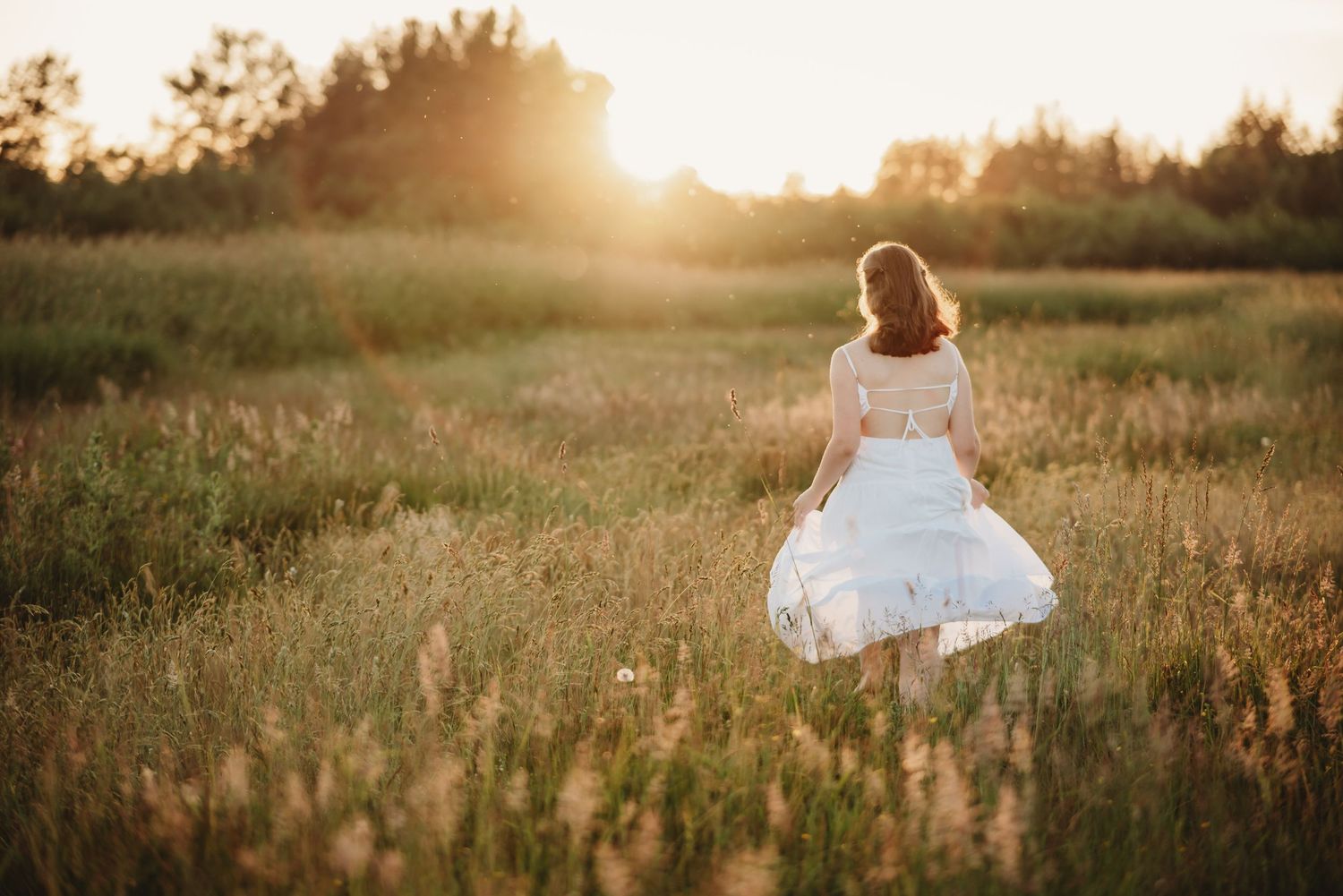 senior girl runs through a golden field at sunset in Skagit County WA