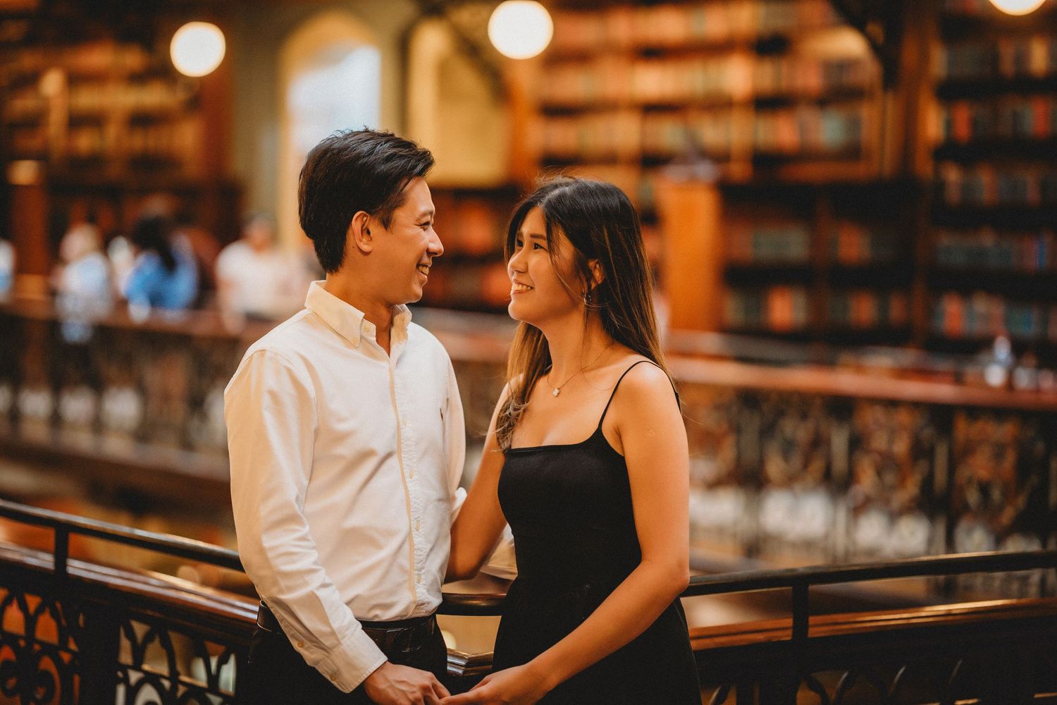 Couple holding hands on an ornate balcony in a heritage library - couple photoshoot ideas by Sydney couple photographer Purple Bird