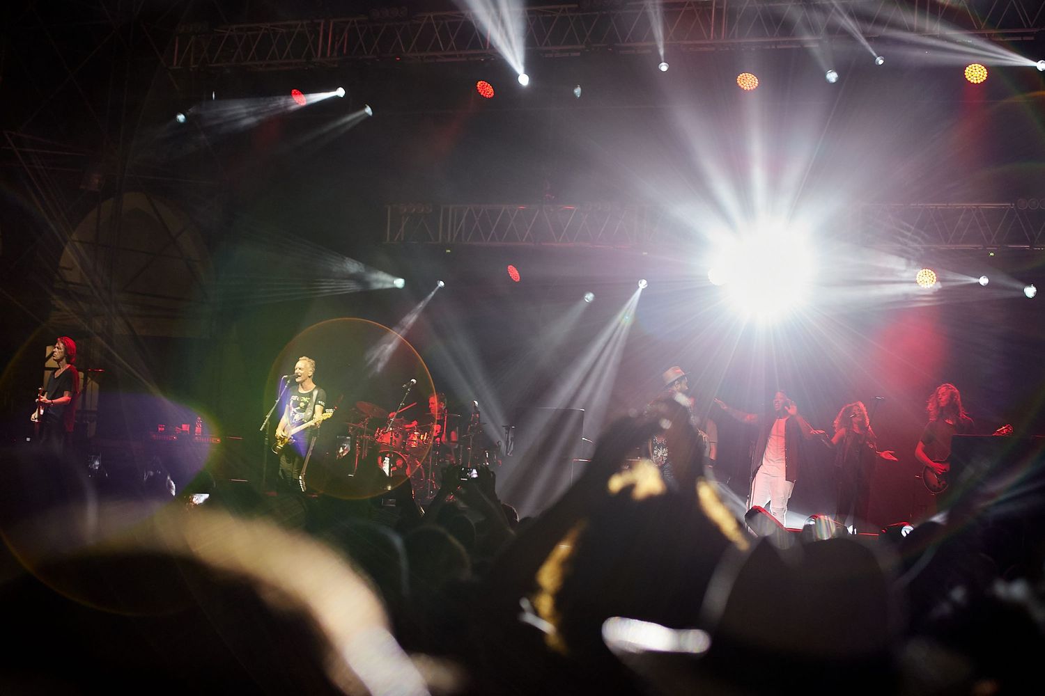 Concert stage with dramatic lighting and smoke effects during live performance.