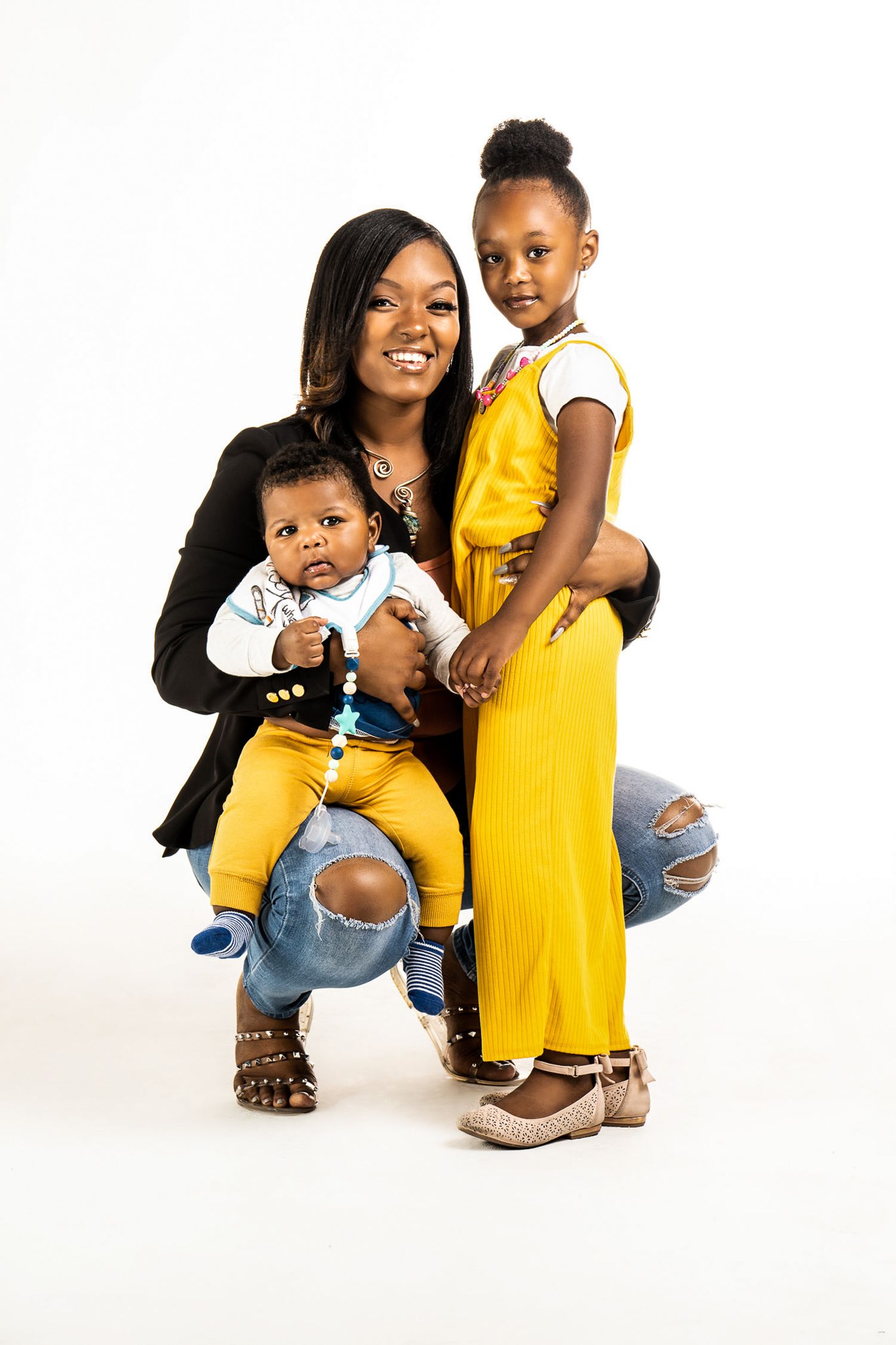 A family portrait against a white background featuring coordinated yellow and black outfits.