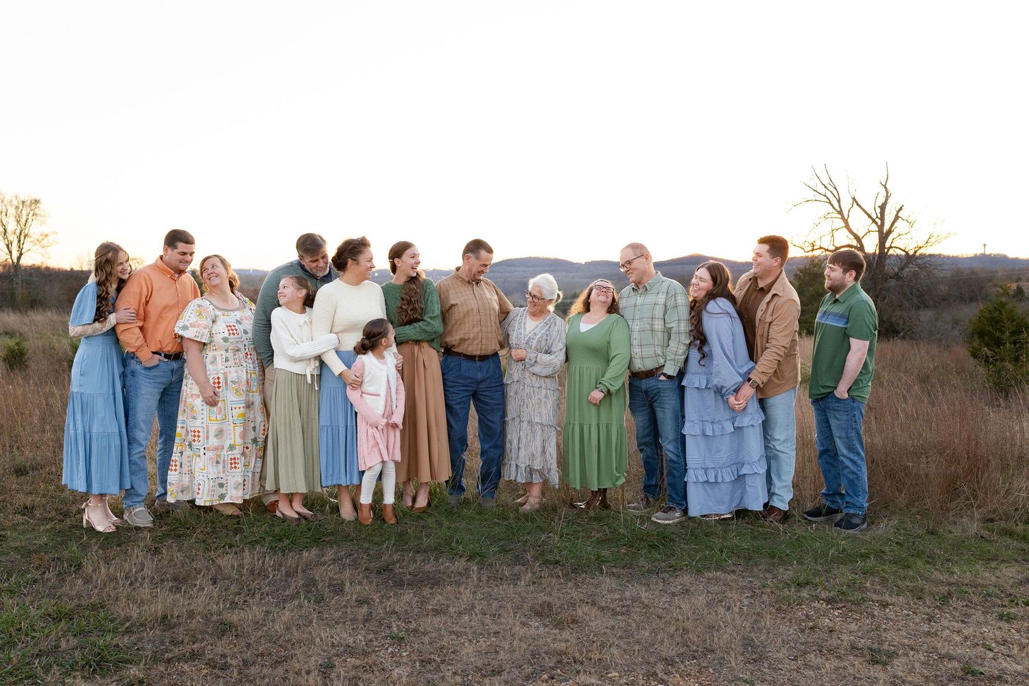 Large family group posing outdoors in front of a rustic wooden barn at Water Mill Cove on a sunny day.