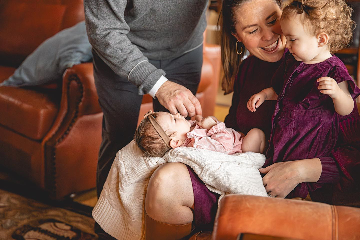 mother holding newborn and toddler daughter