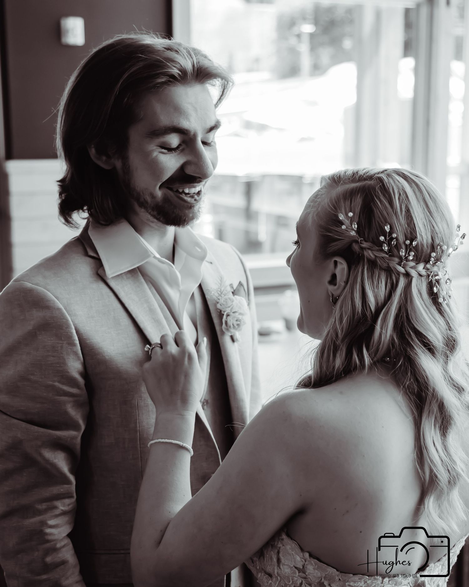 A romantic black and white moment between newlyweds captured in soft window light.