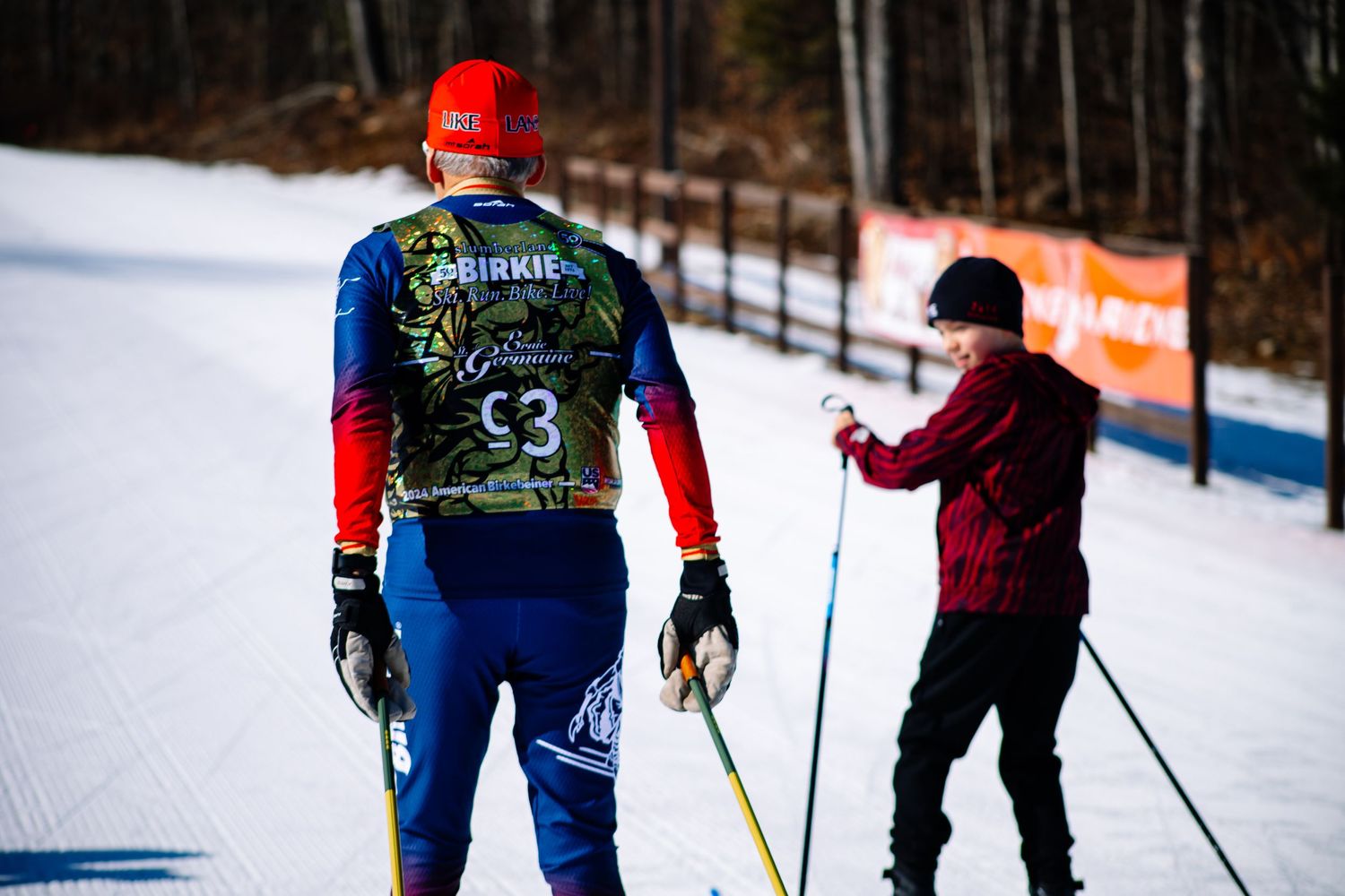 Cross country skiers practice on a snowy trail with winter gear at a Nordic ski resort on a cold day.
