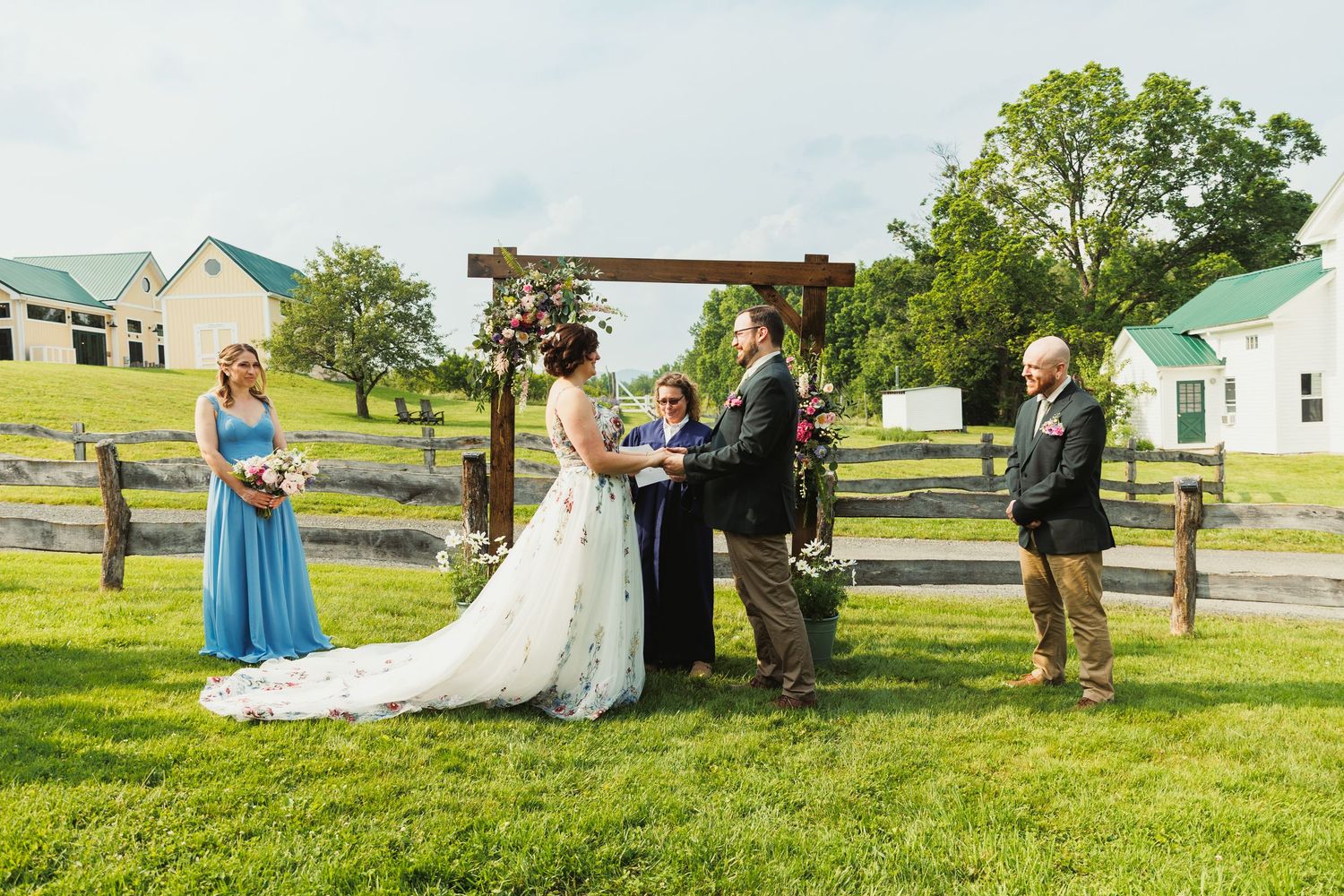 Outdoor wedding ceremony in a scenic countryside setting with green rolling hills.