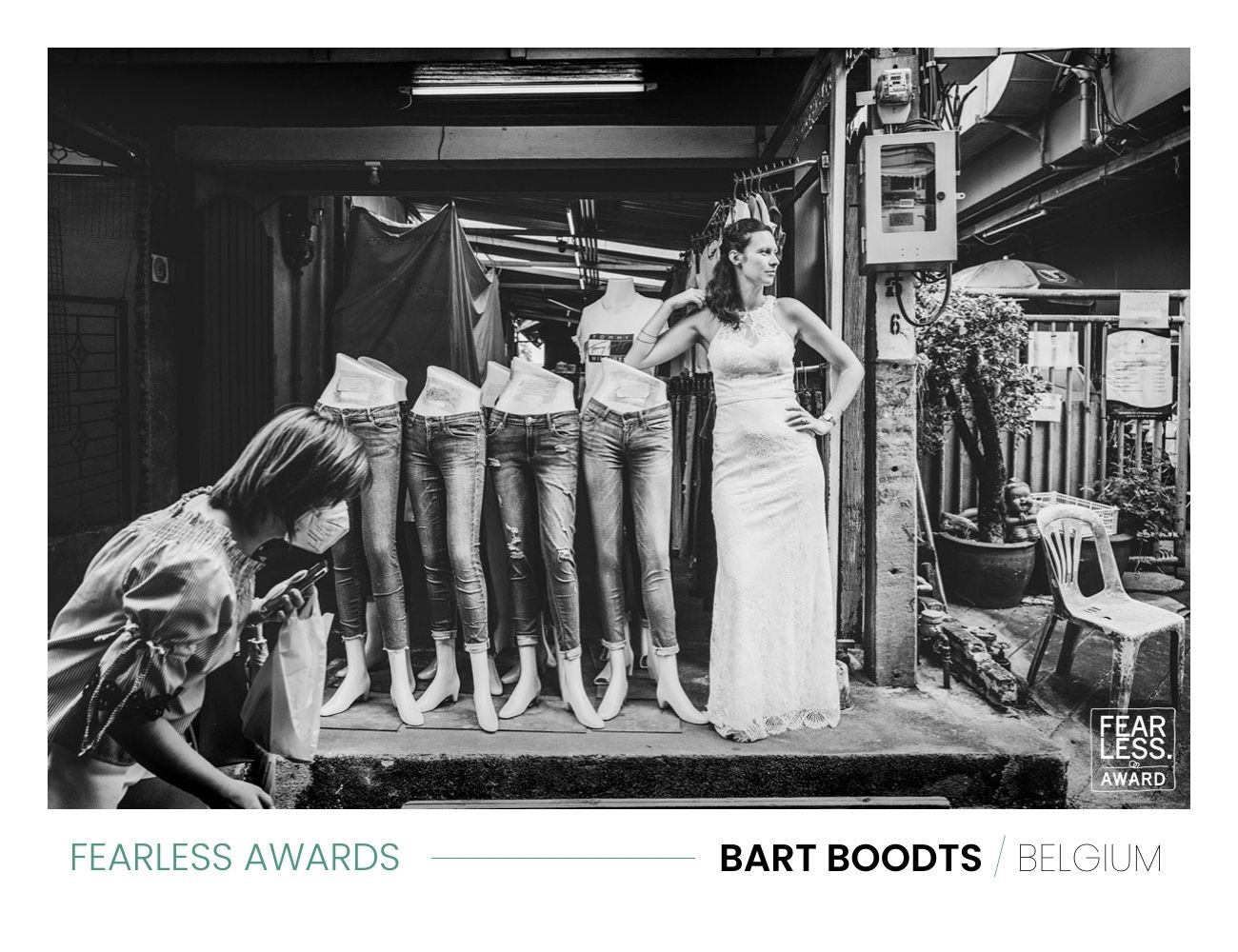 Zwart wit huwelijksfoto met bruid in straatdecor, bekroond met een Fearless Award, creatief vastgelegd door Bart Boodts.
