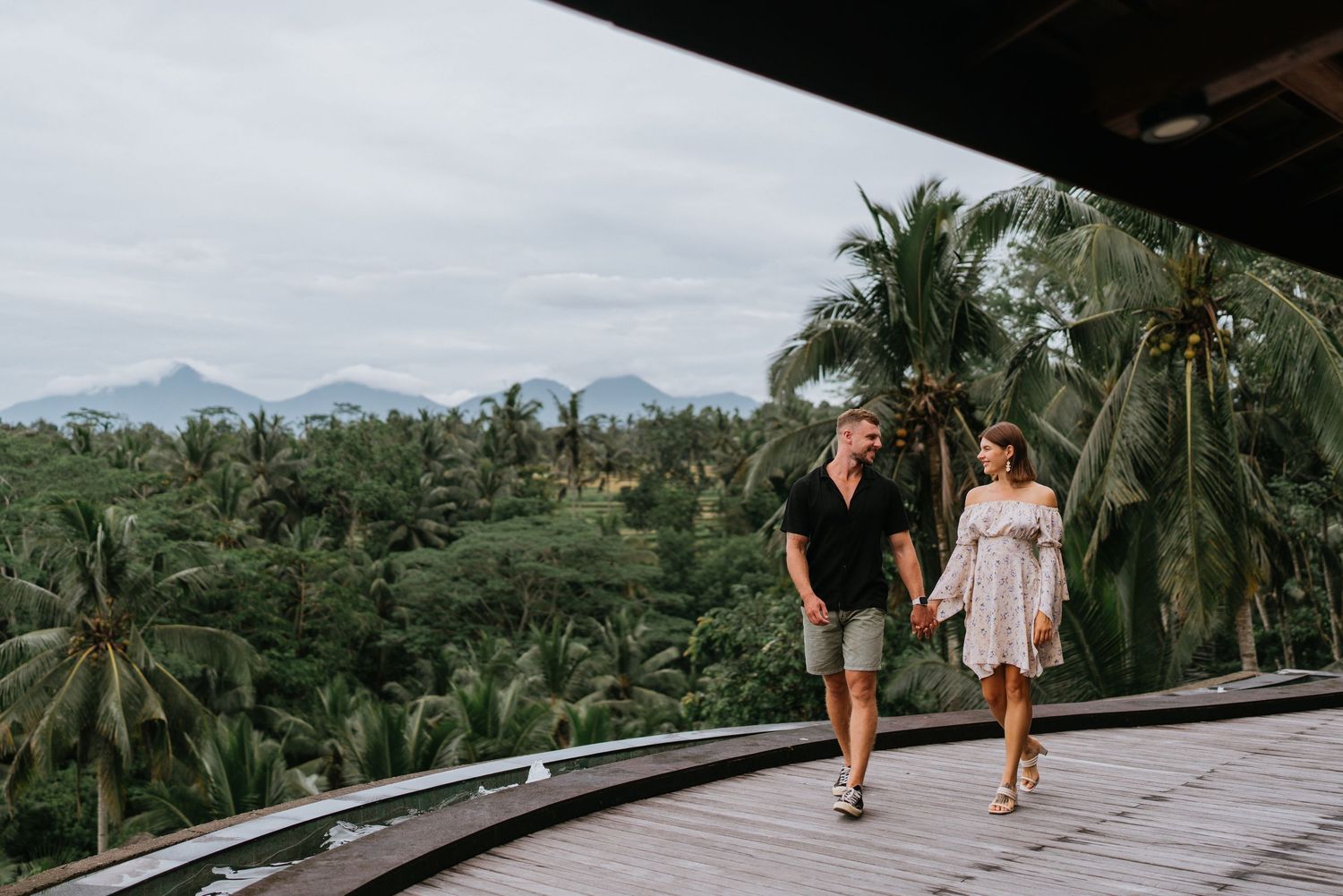 Elevated view of a wooden observation deck surrounded by palm trees and tropical greenery.