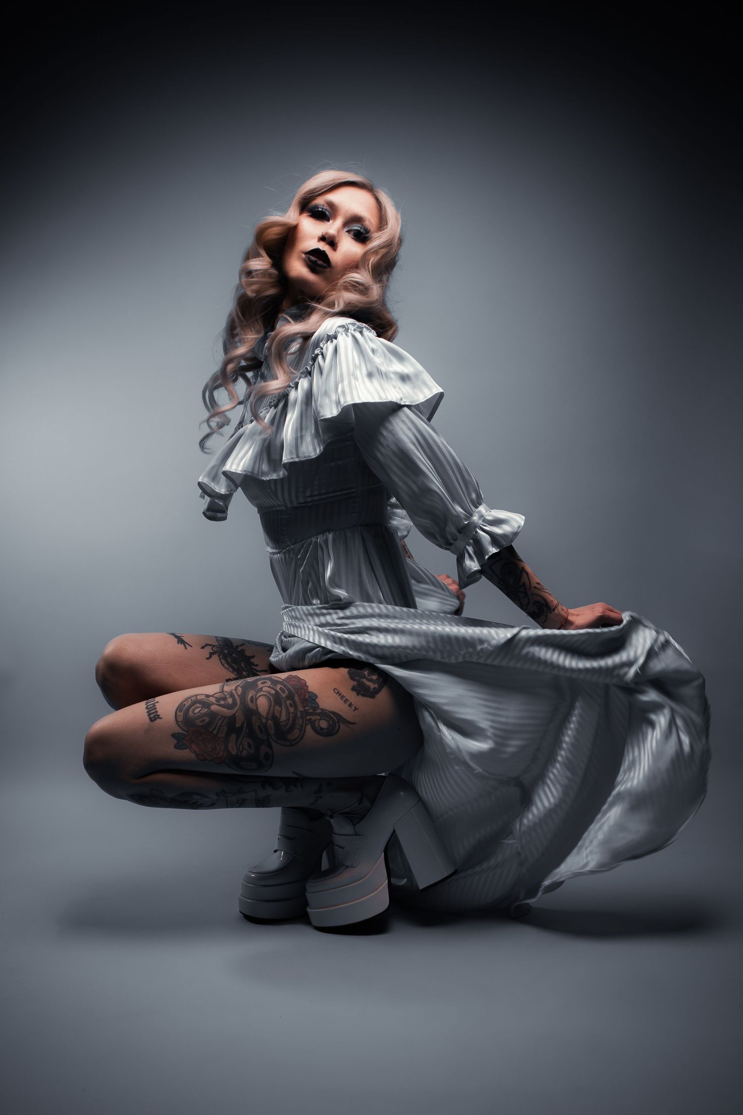 Man sitting in an open car door holding a drink, styled portrait for editorial vs fashion photography blog