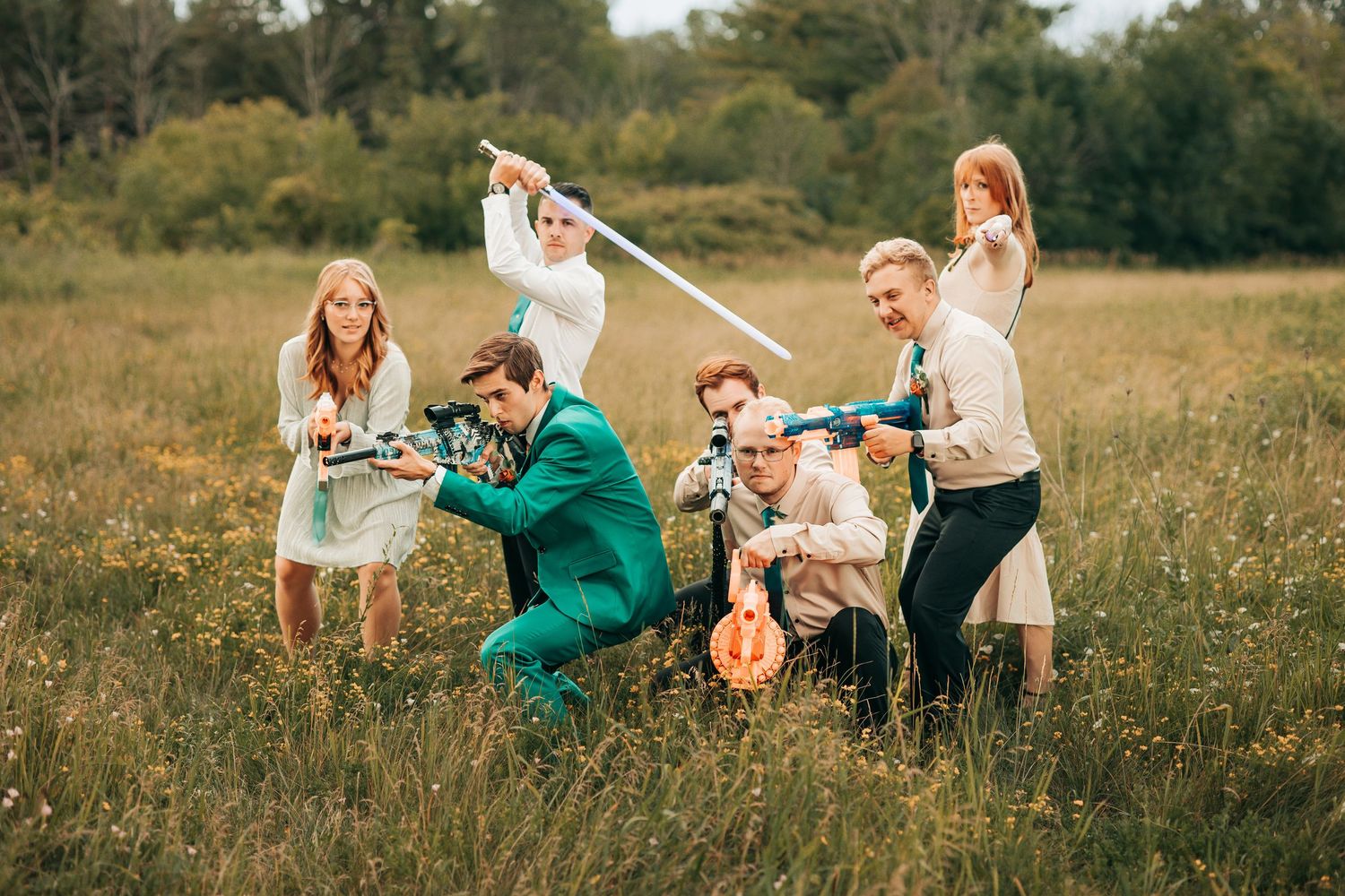 A group enjoys a playful moment together while sitting in a grassy meadow on a sunny afternoon.
