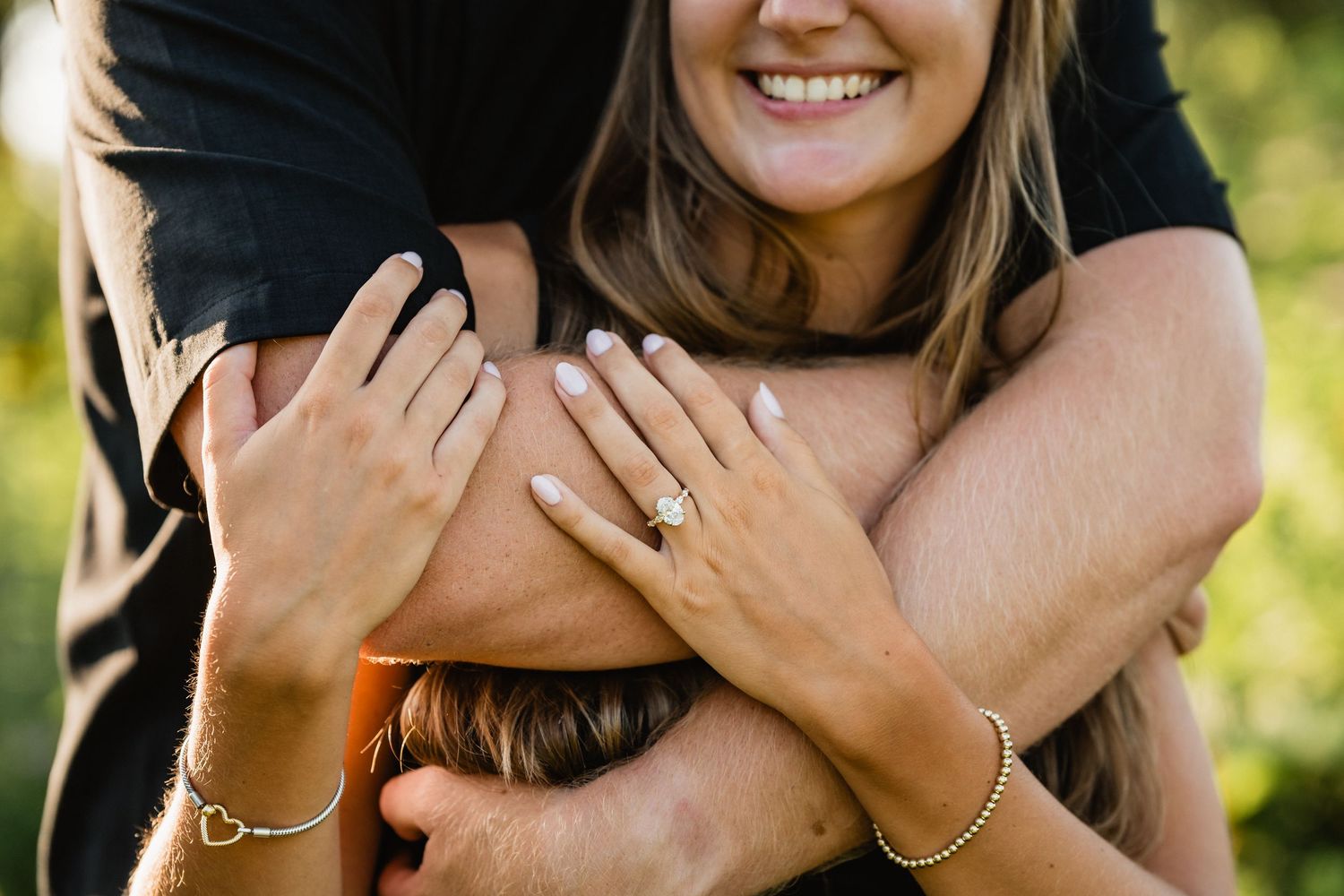 Jacob hugs Morgan as she smiles and shows off her new engagement ring.