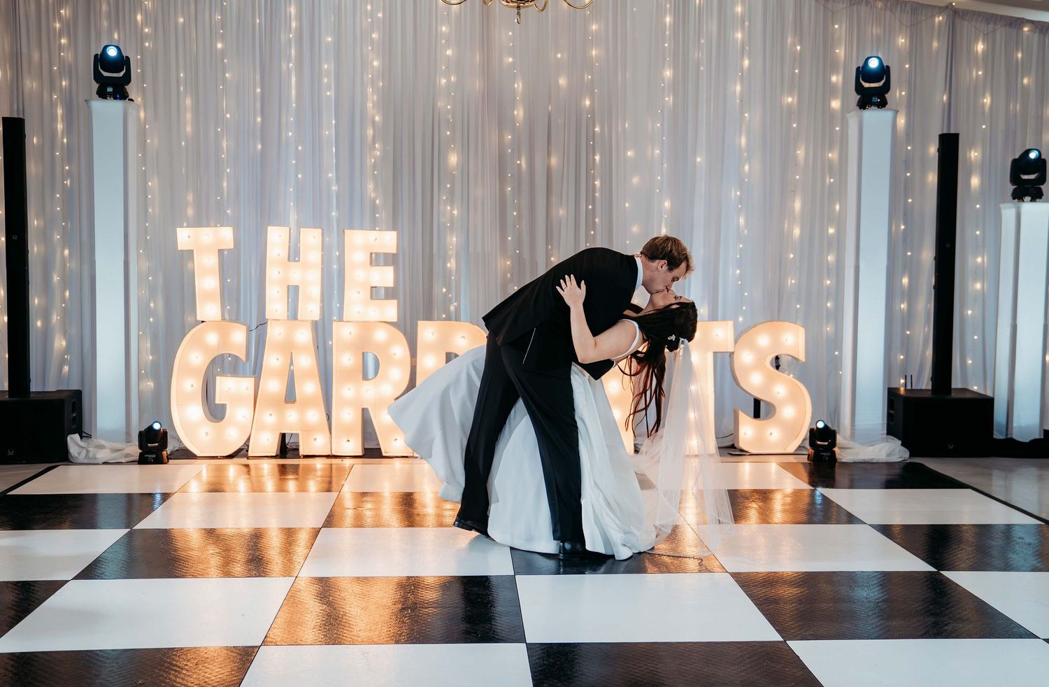 Illuminated marquee letters spelling 'THE CAR' glow against a white wall with silhouettes walking past.