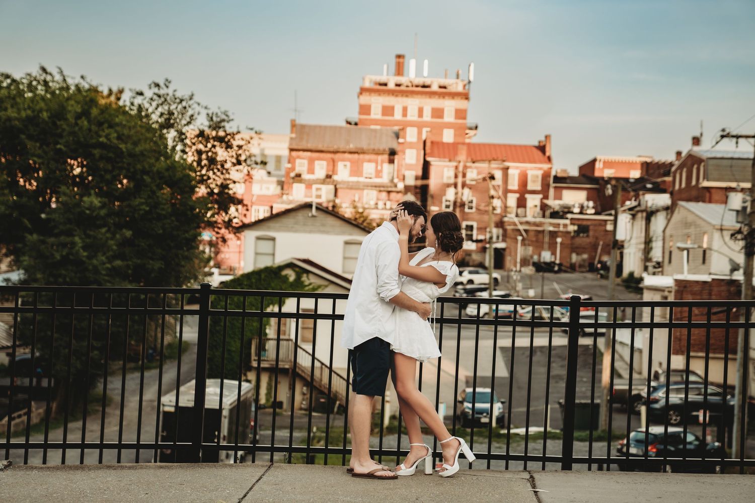 People walking along an urban balcony with historic buildings in the background.
