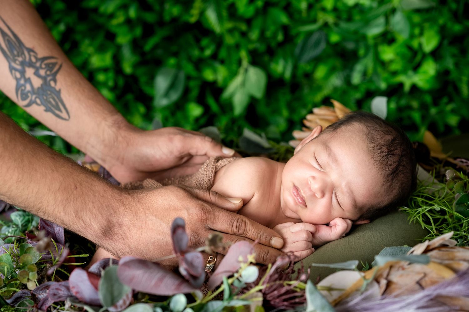 A person receives a relaxing therapeutic massage treatment on a table surrounded by lush green plants.