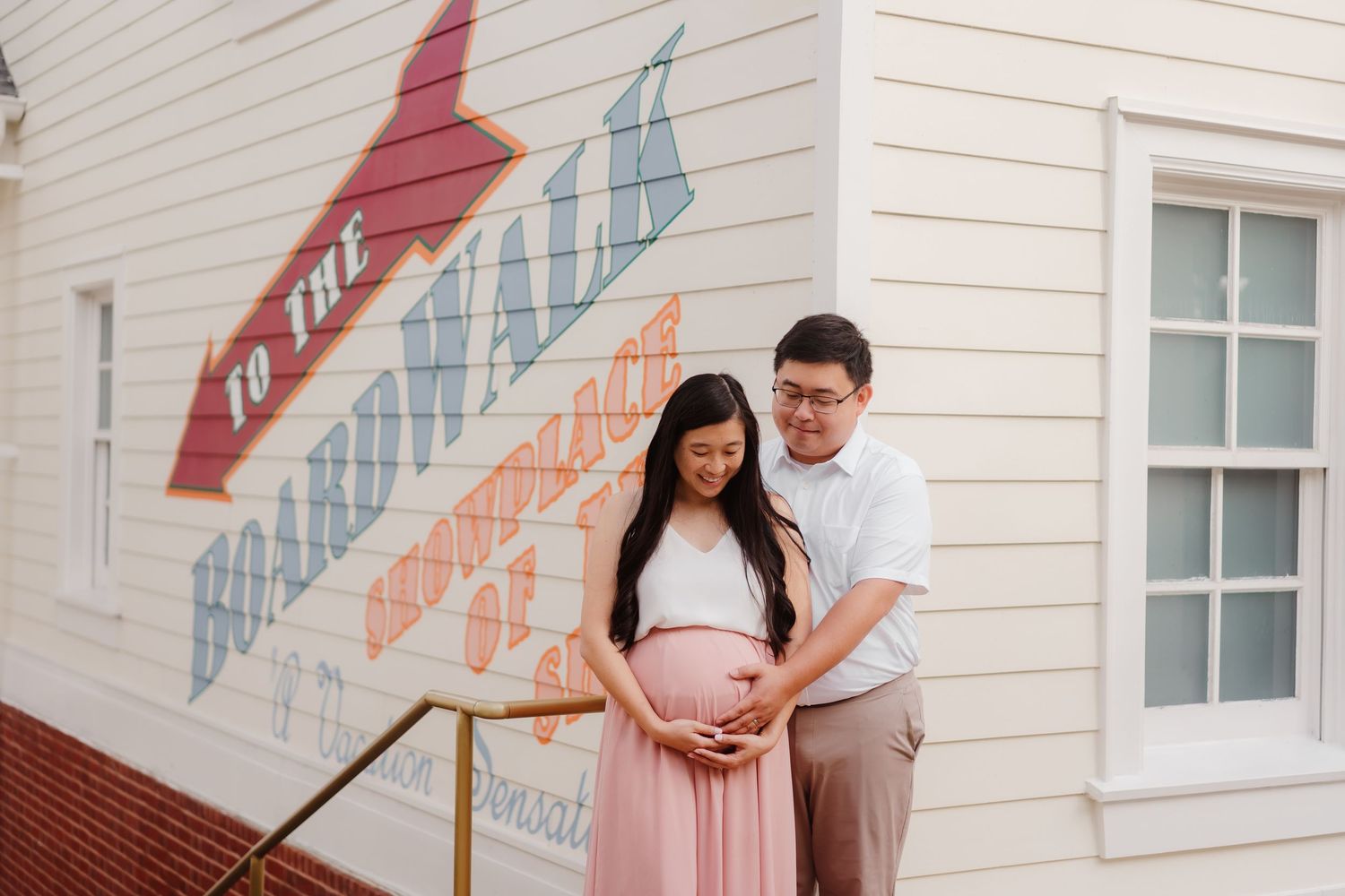 A series of four romantic engagement photos showing a couple embracing against a white house exterior.