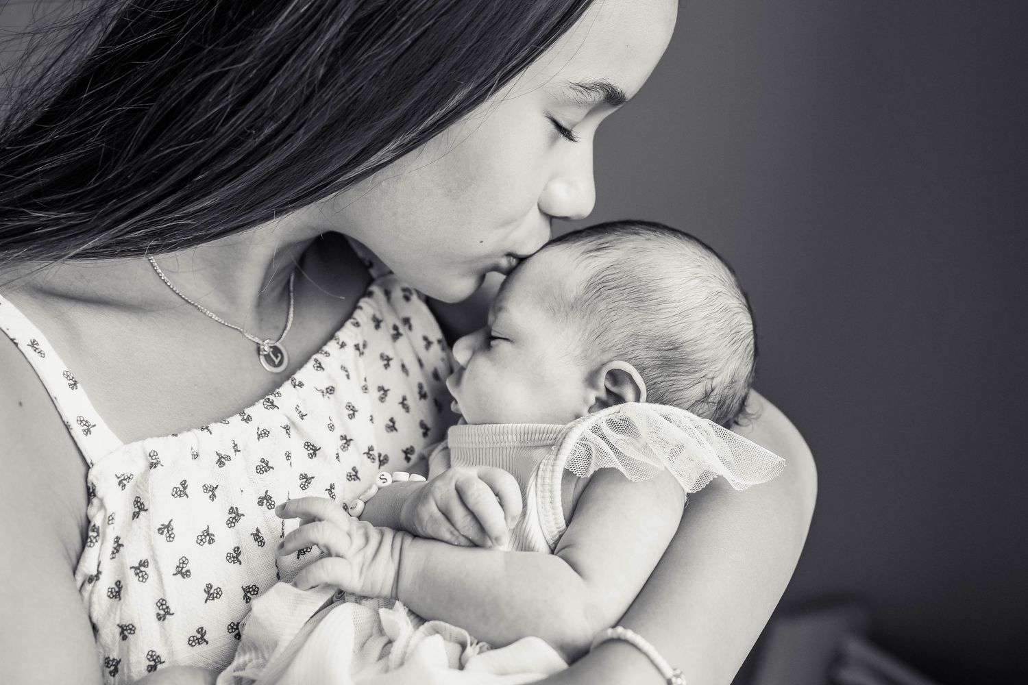 Sister kissing newborn sister.
