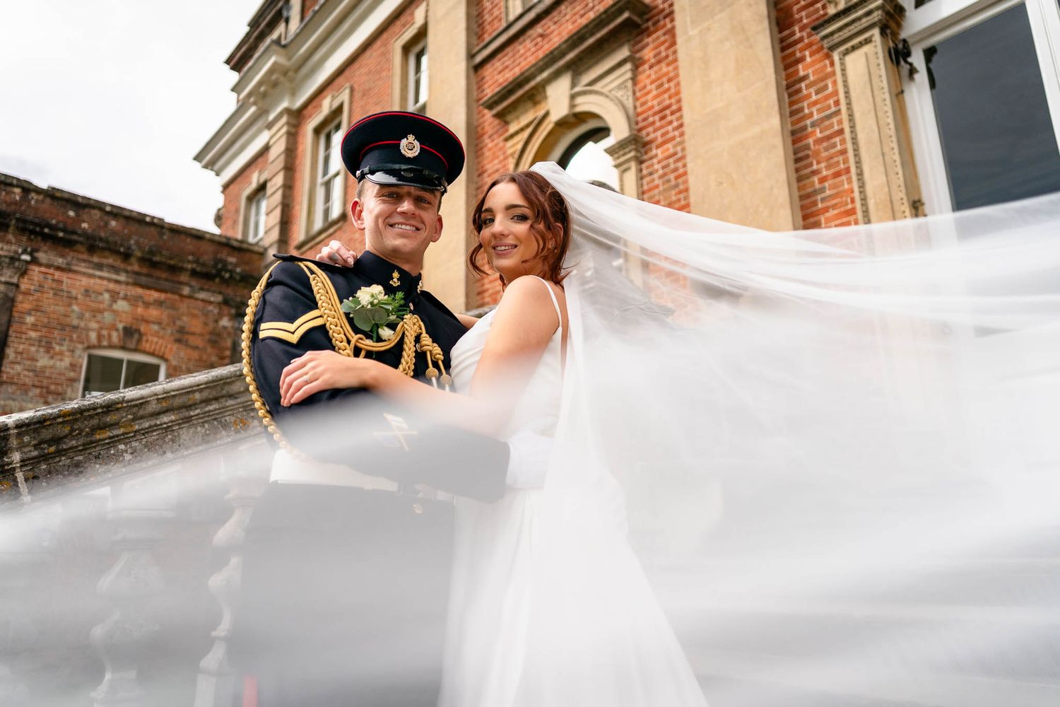 Newly married couple in front of rustic farm house at Ash Barton Estate in North Devon.