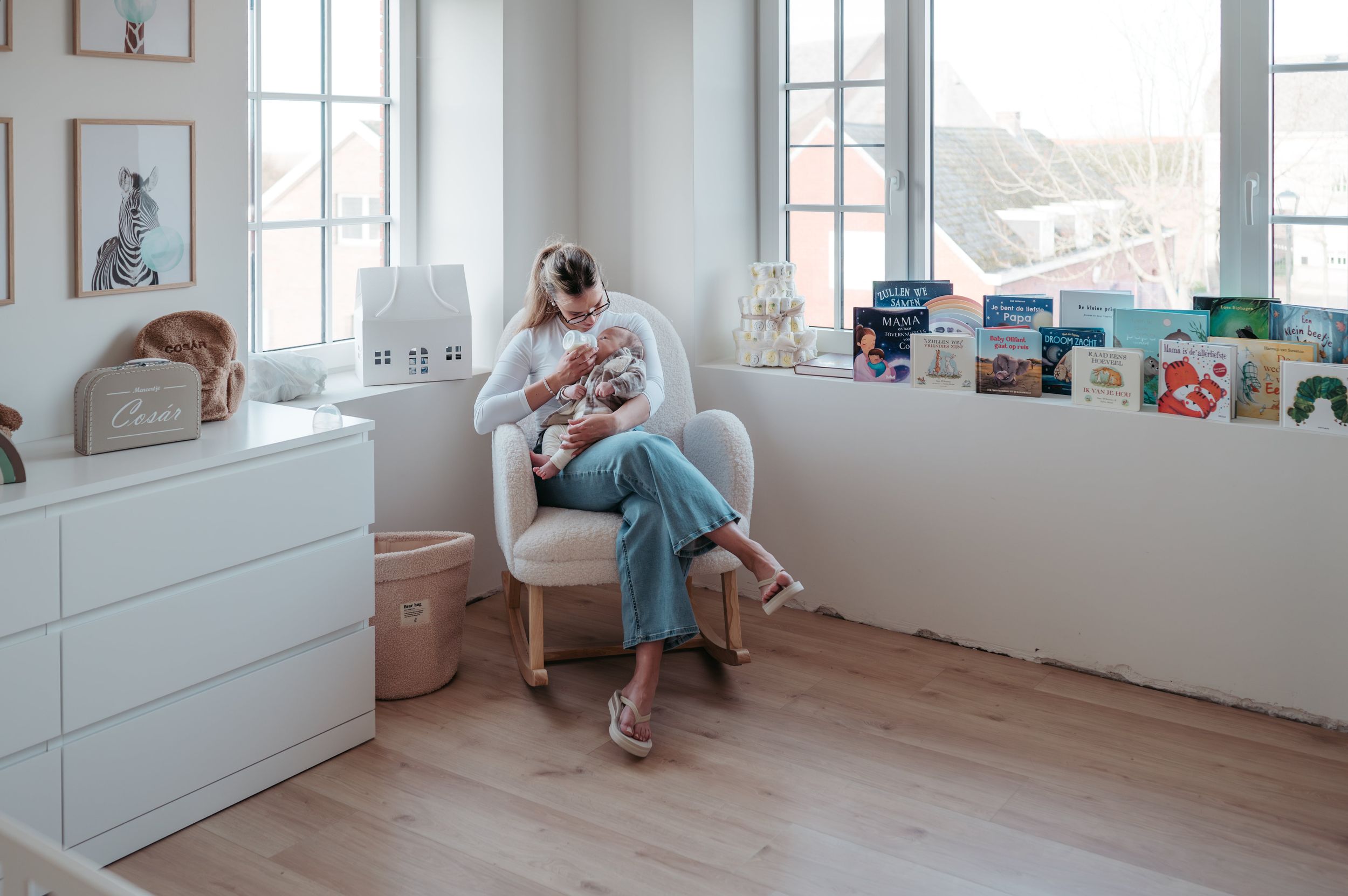 Mama die baby flesje geeft in de babykamer. 7 tips van een mama van 3 en moederschapsfotograaf uit Moerbeke om je huis babyproof te maken
