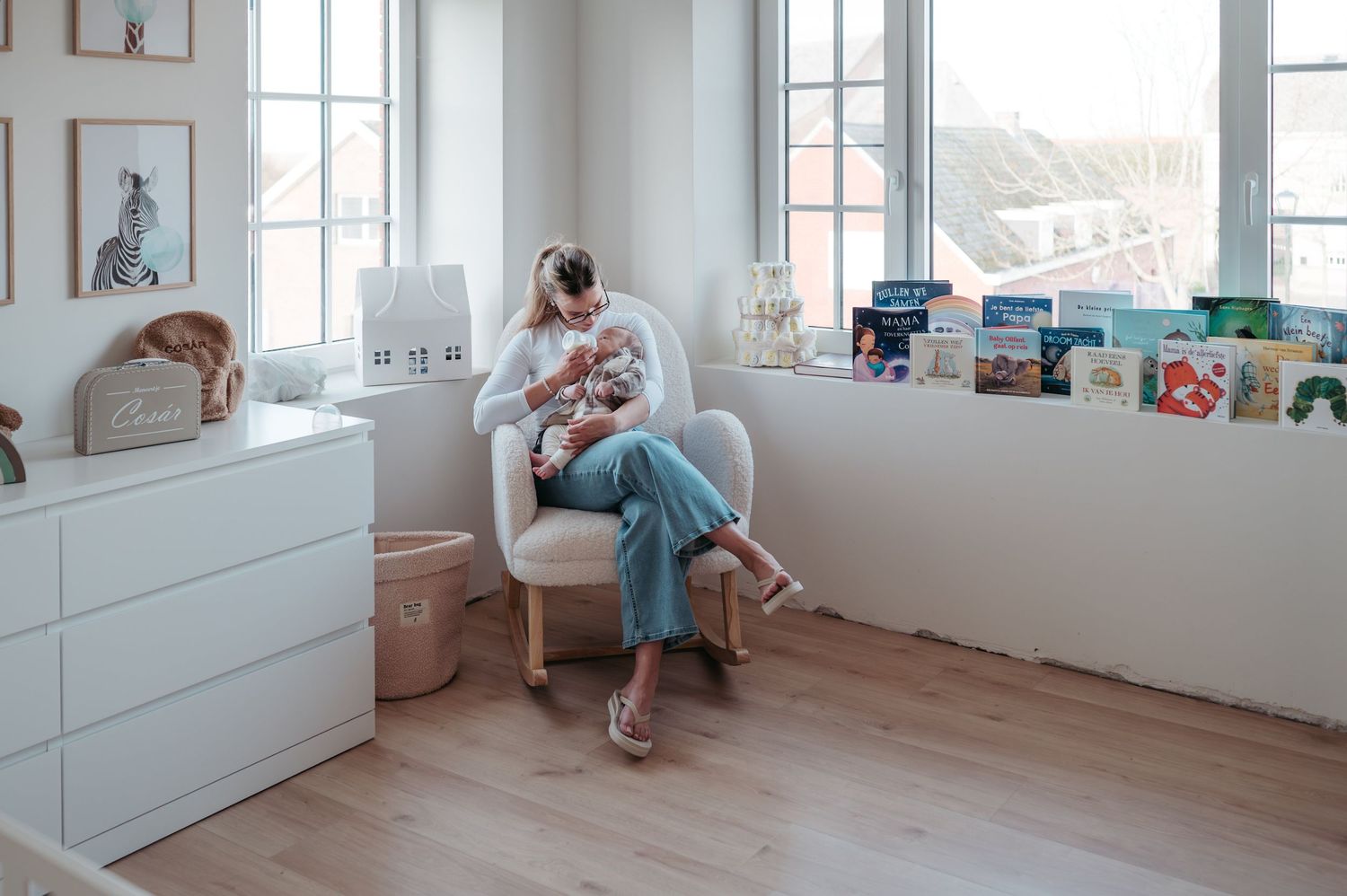 Mama die baby flesje geeft in de babykamer. 7 tips van een mama van 3 en moederschapsfotograaf uit Moerbeke om je huis babyproof te maken