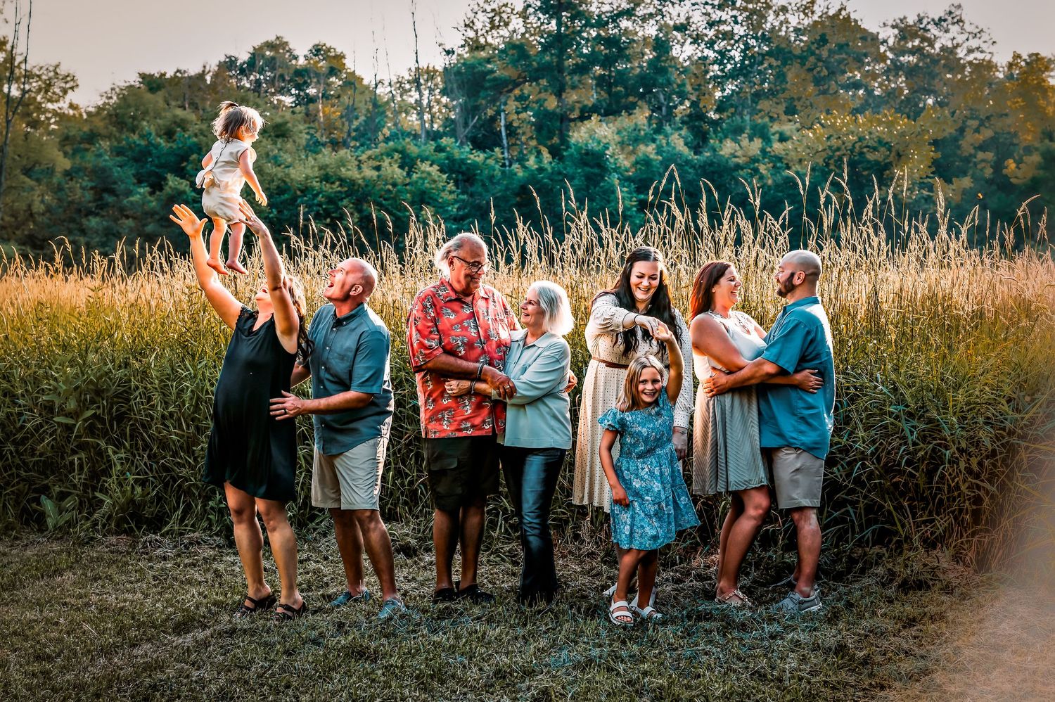 A group of people walking and playing together on a scenic outdoor path during golden hour.