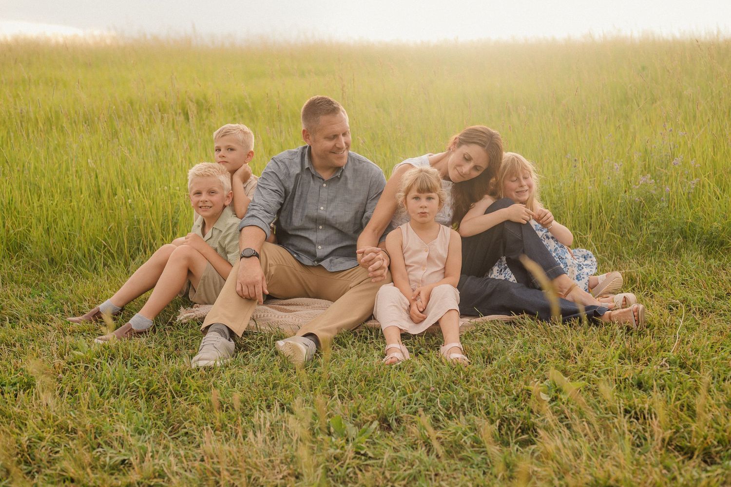 A joyful black and white family photo of people playing together in a field.
