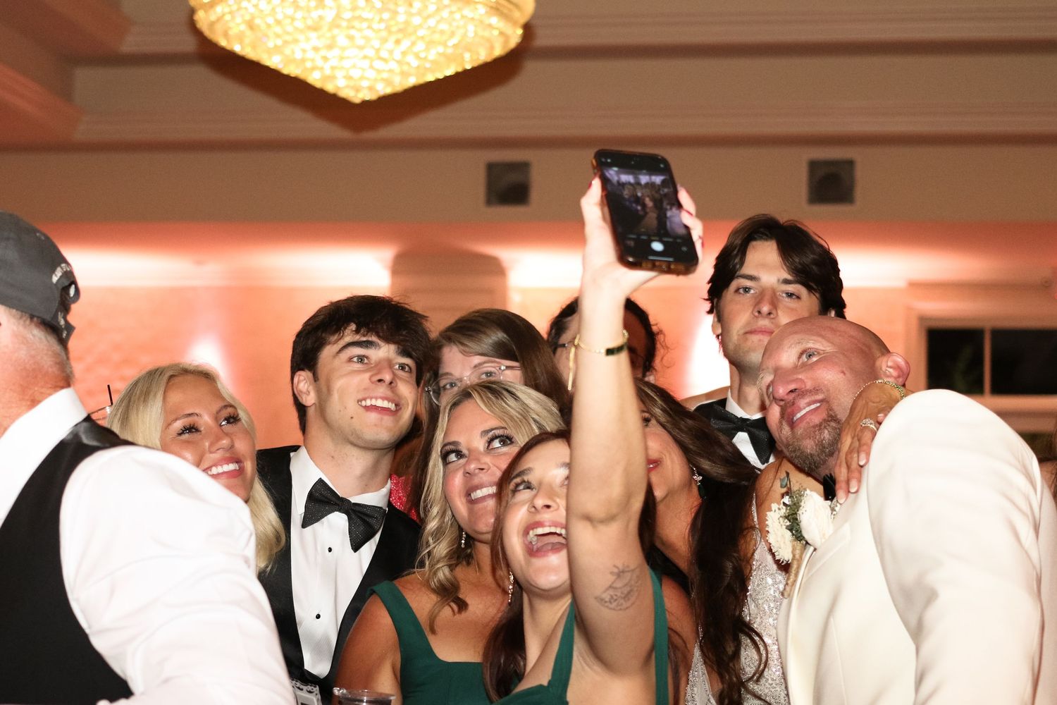 Collage of candid reception photos showing guests laughing and dancing in a warm-lit party environment.