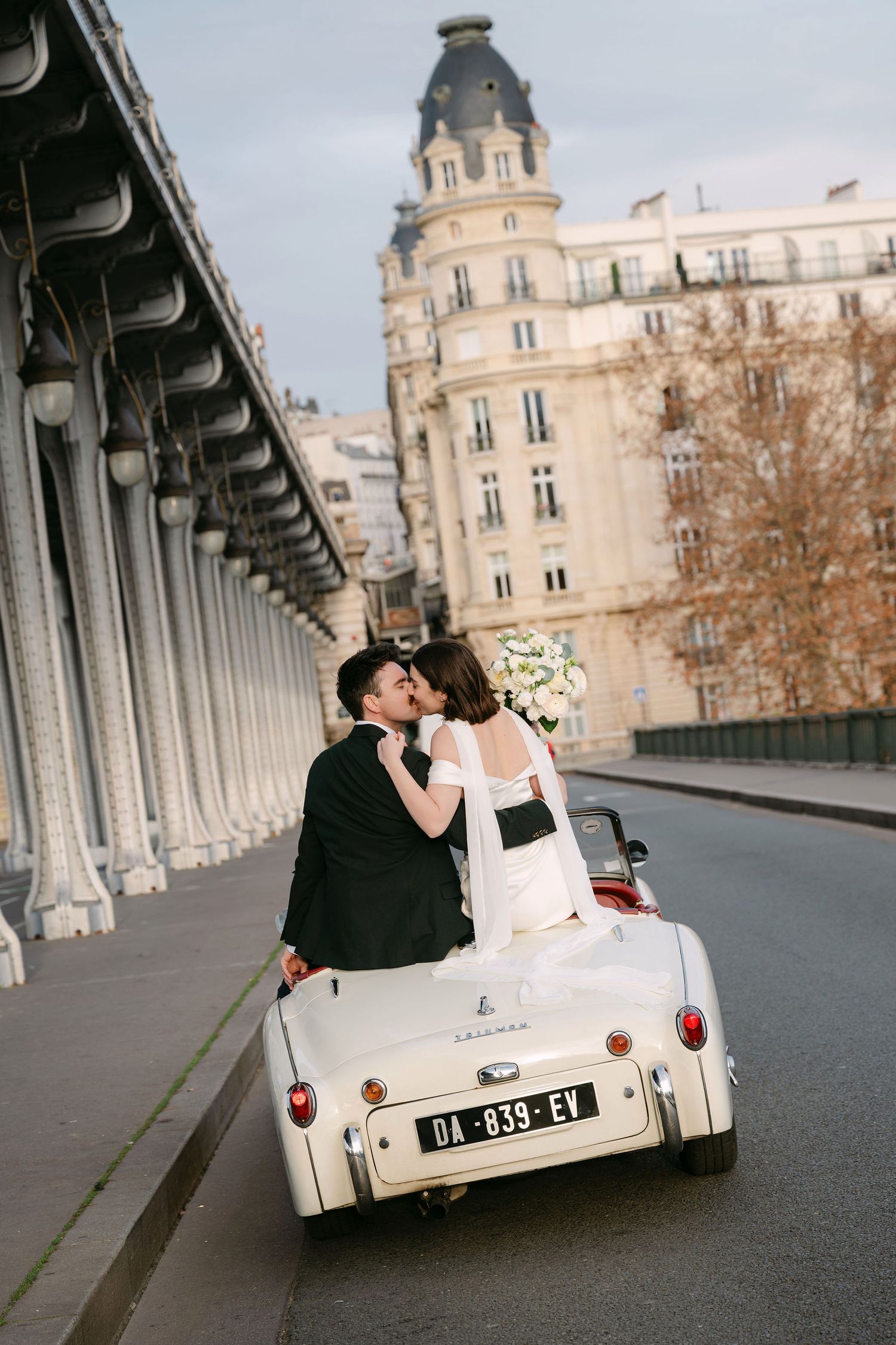 A classic vintage car on Bir-Hakeim Bridge in Paris with romantic couple in the background. How I would plan your Paris Elopement