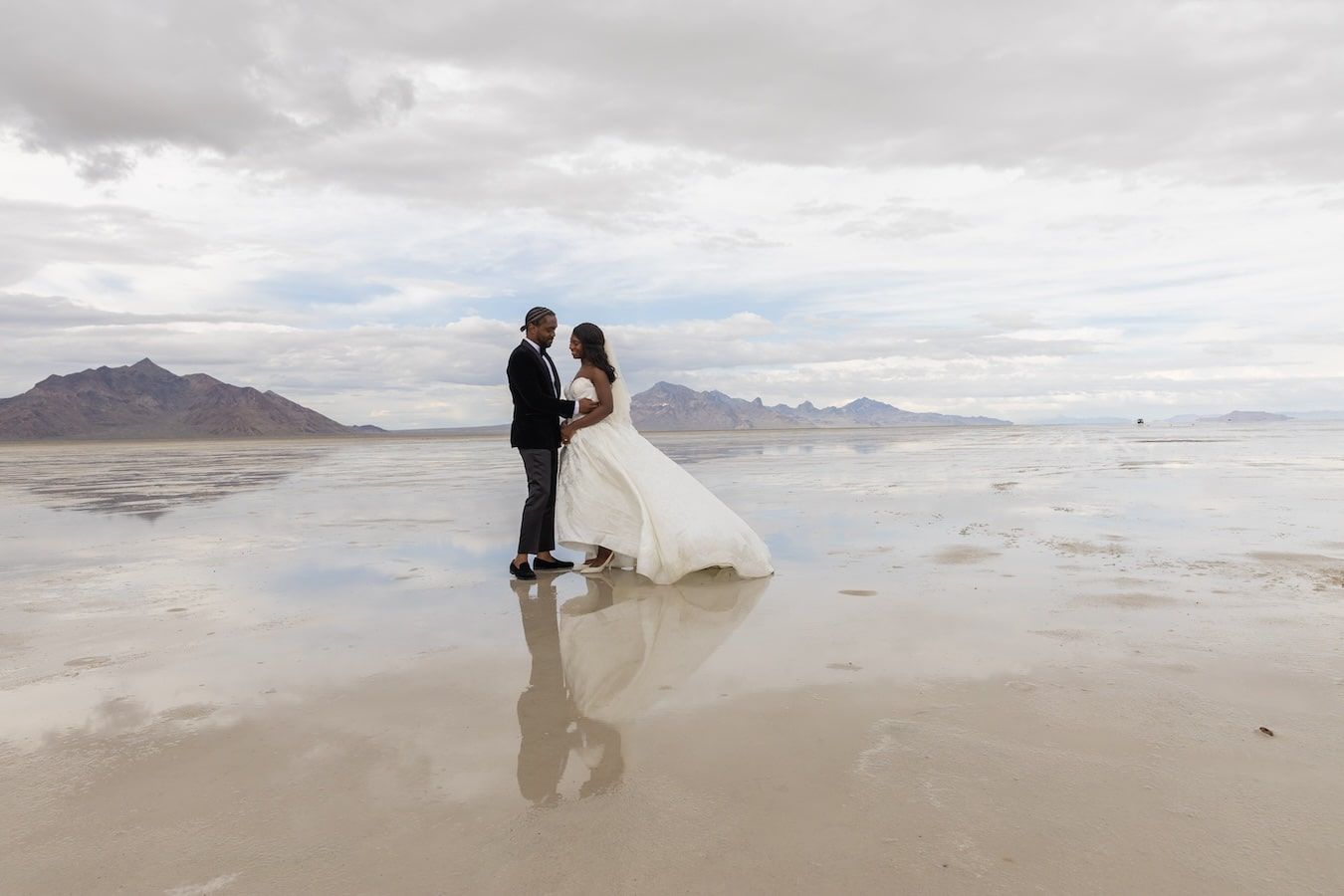 Newlyweds pose together during a romantic photo shoot on the scenic Bonneville Salt Flats in Utah.