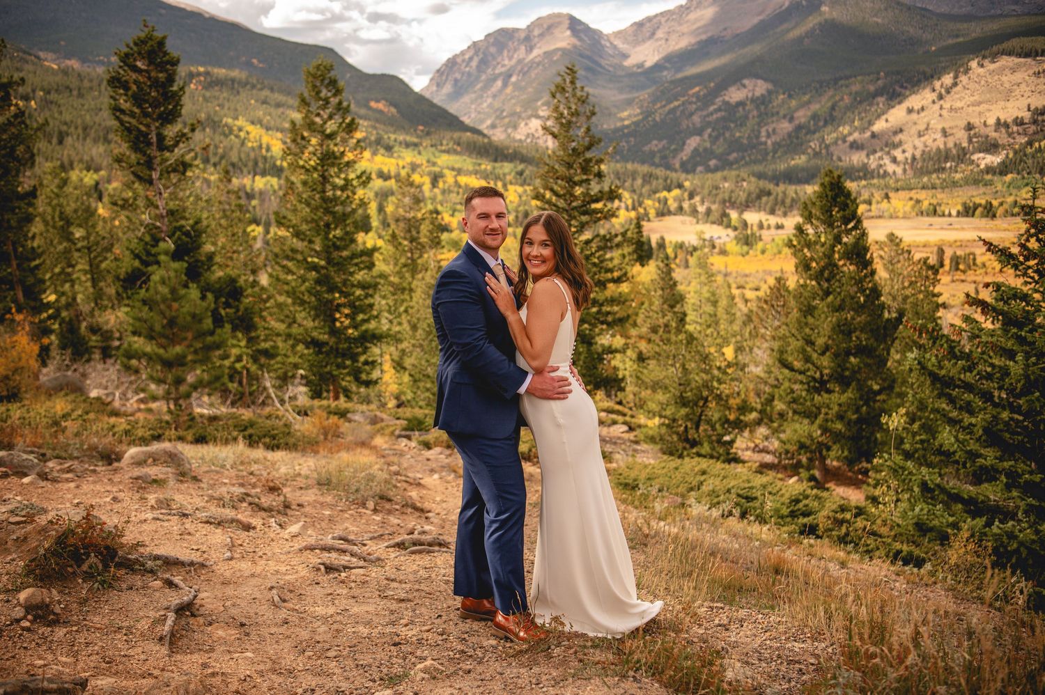 A couple shares an intimate moment during their mountain wedding in Colorado's scenic wilderness at sunset.