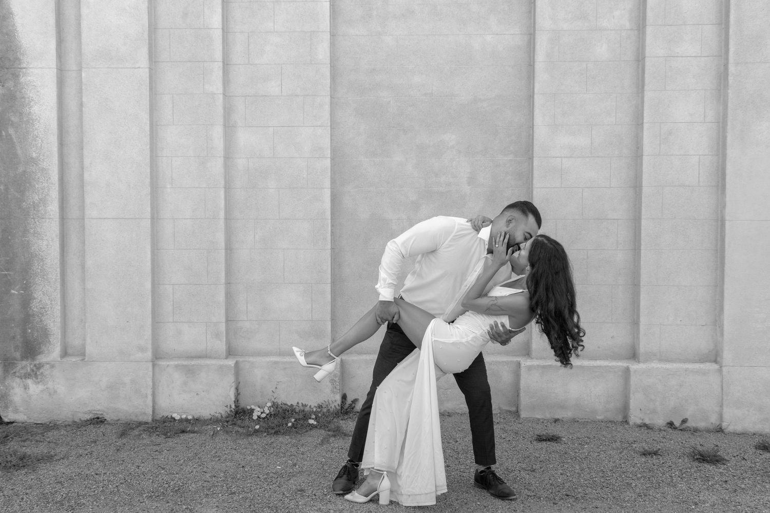 A man dipping a woman while they share a kiss.