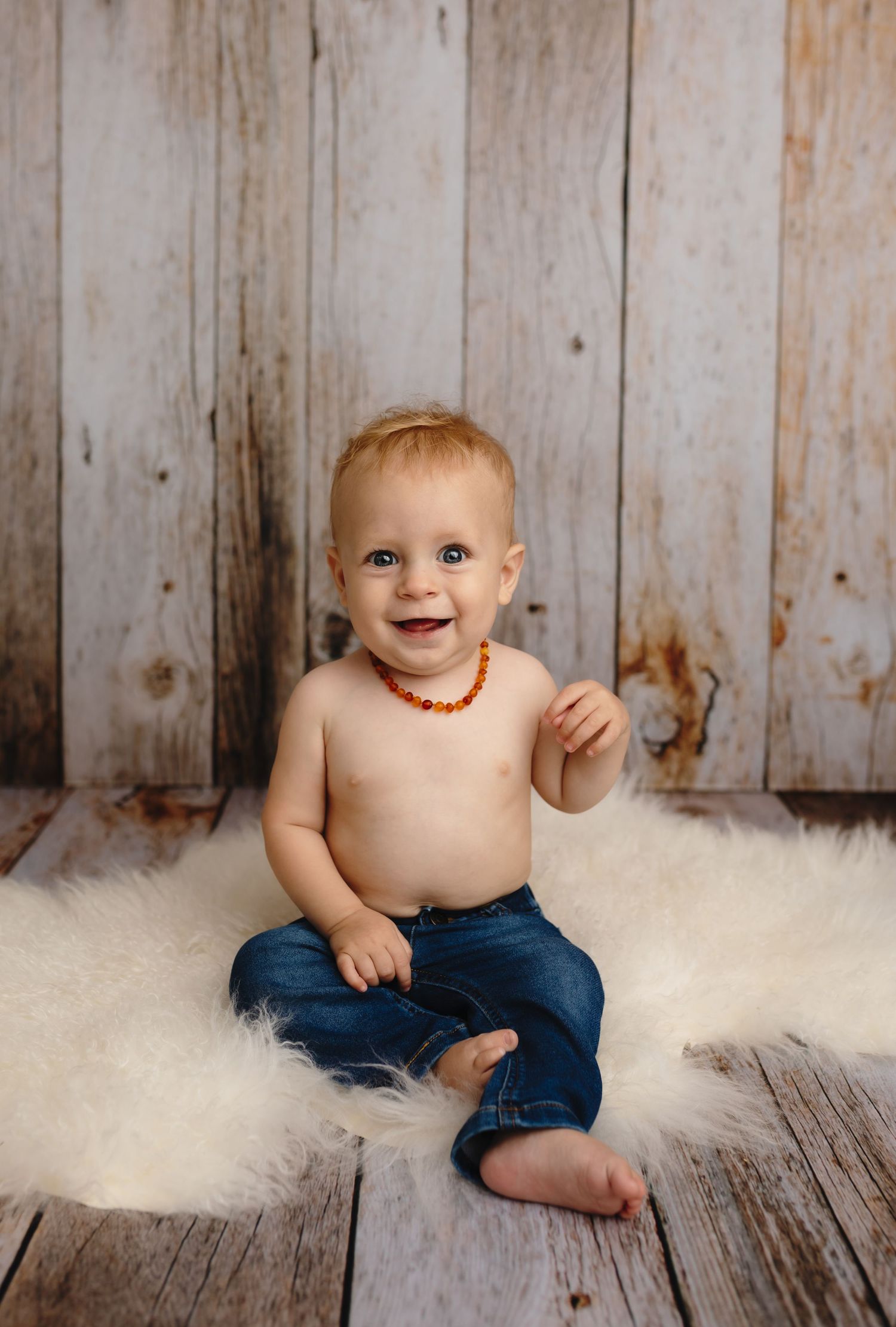 Charlottesville photographer, baby, newborn, family, maternity, baby boy wearing jeans and smiling on flokati
