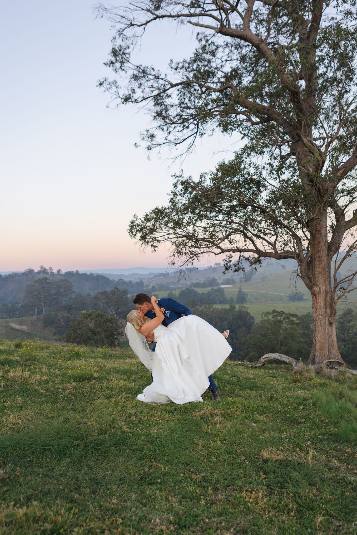 bride and groom in dip kiss on mountain top at Dungog Weddings in Hunter Valley NSW