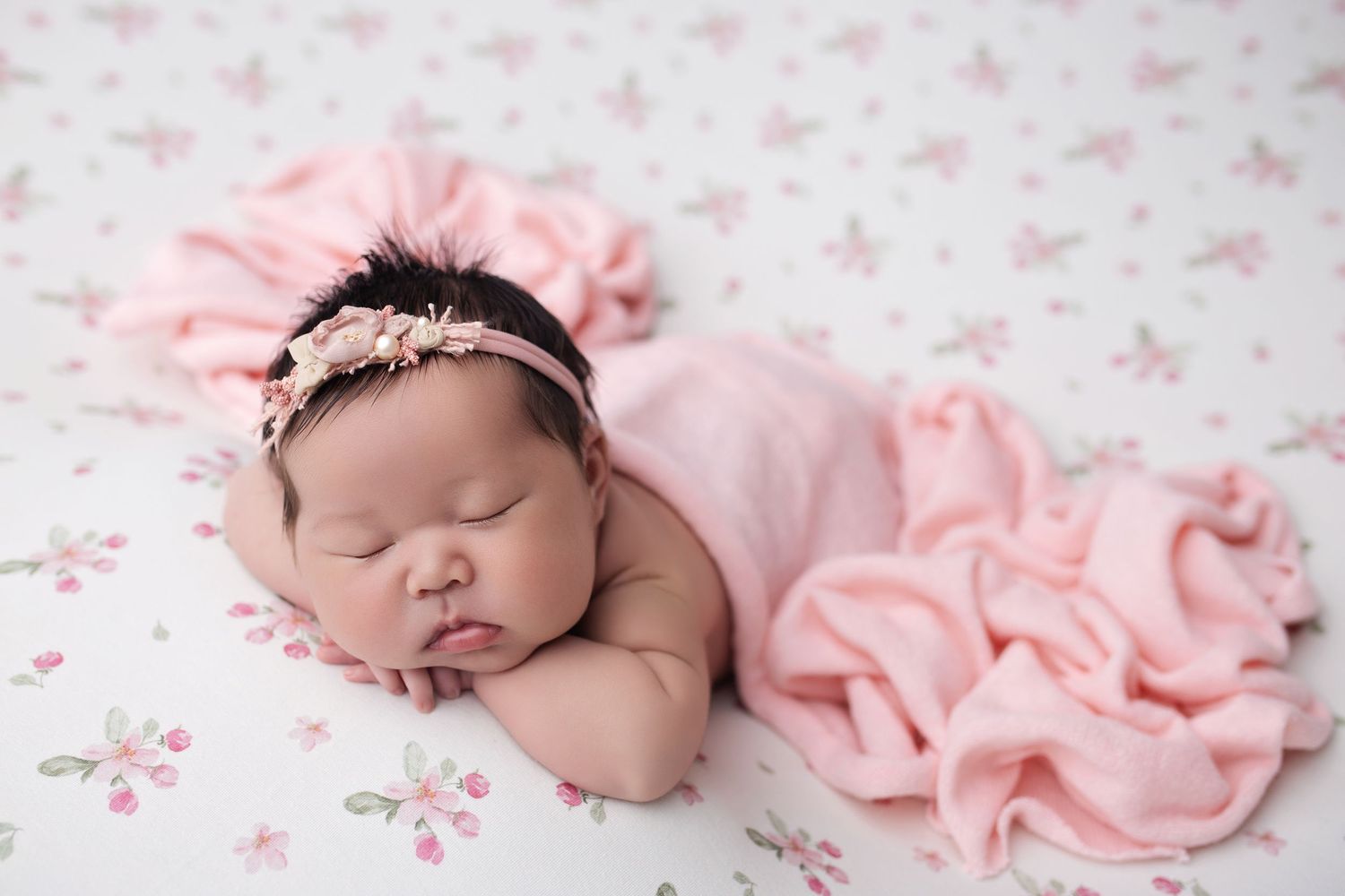 Sleeping newborn in gray knit hat on charcoal fabric.