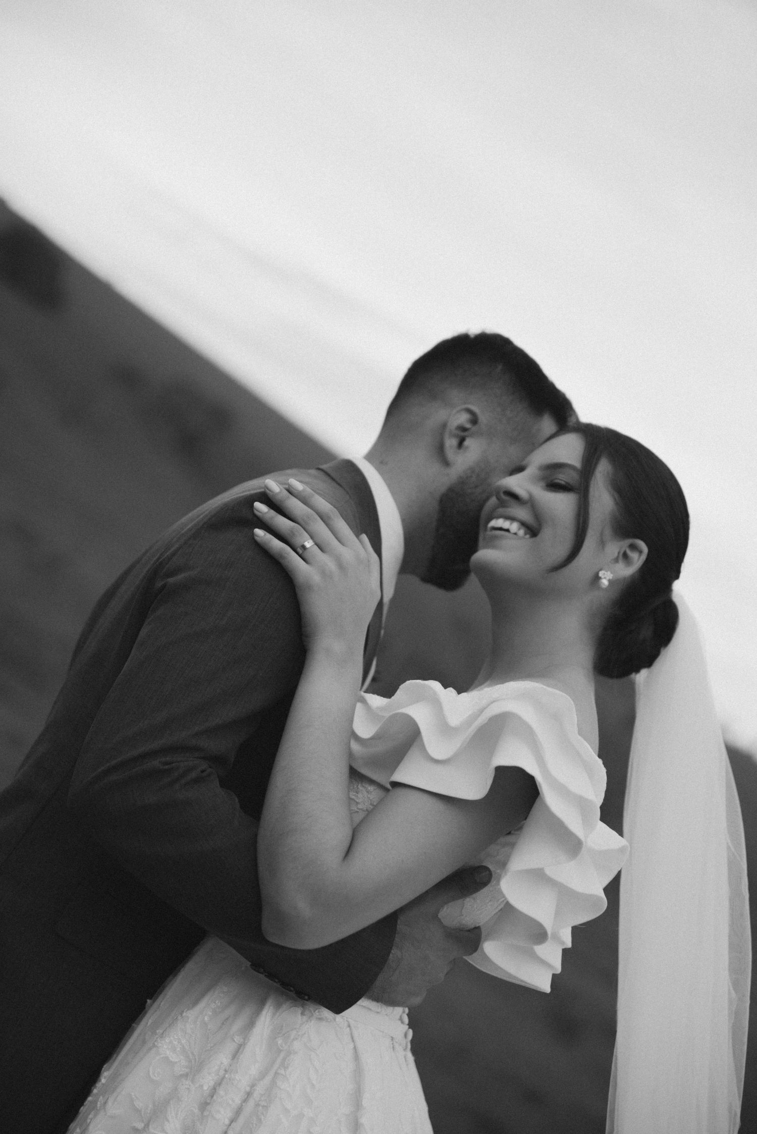 Black and white portrait of newlyweds sharing an intimate moment.