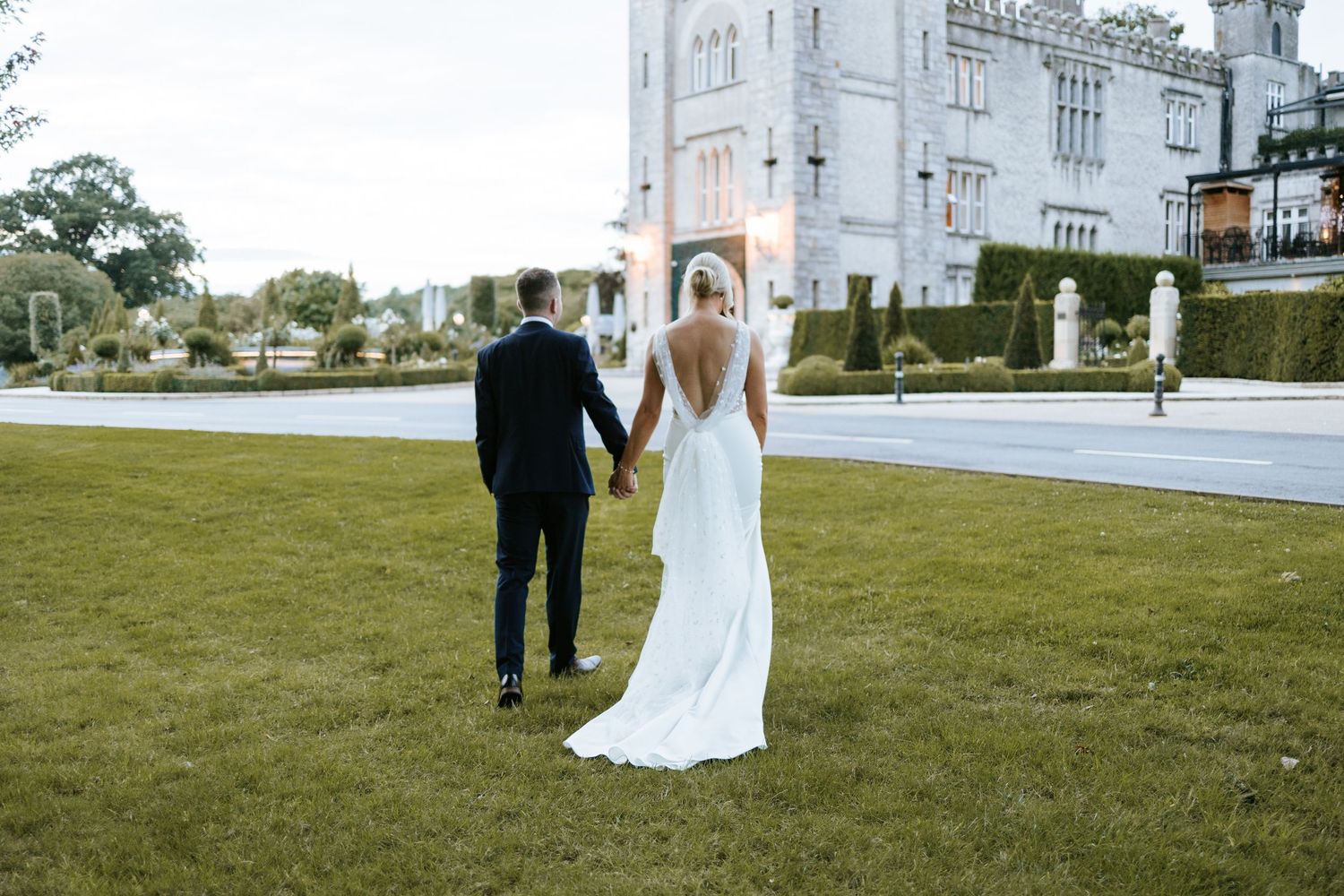 Modern black barn wedding venue with glass features hosting outdoor ceremony.