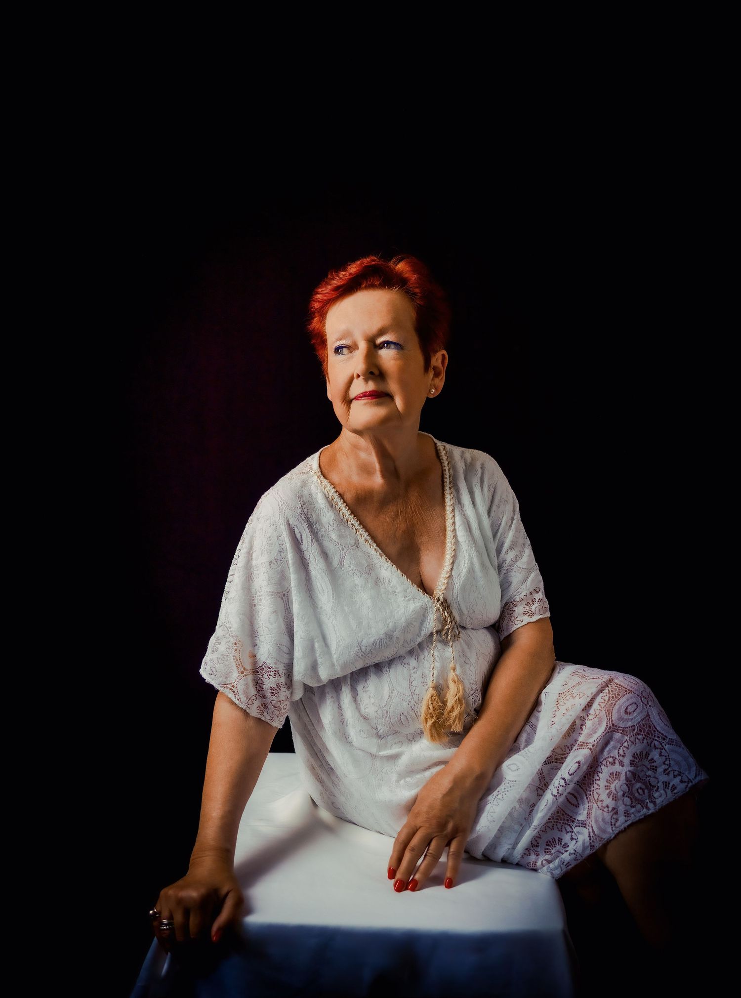 Four dramatic portraits in a series showing a figure seated against a dark background in emotive poses.