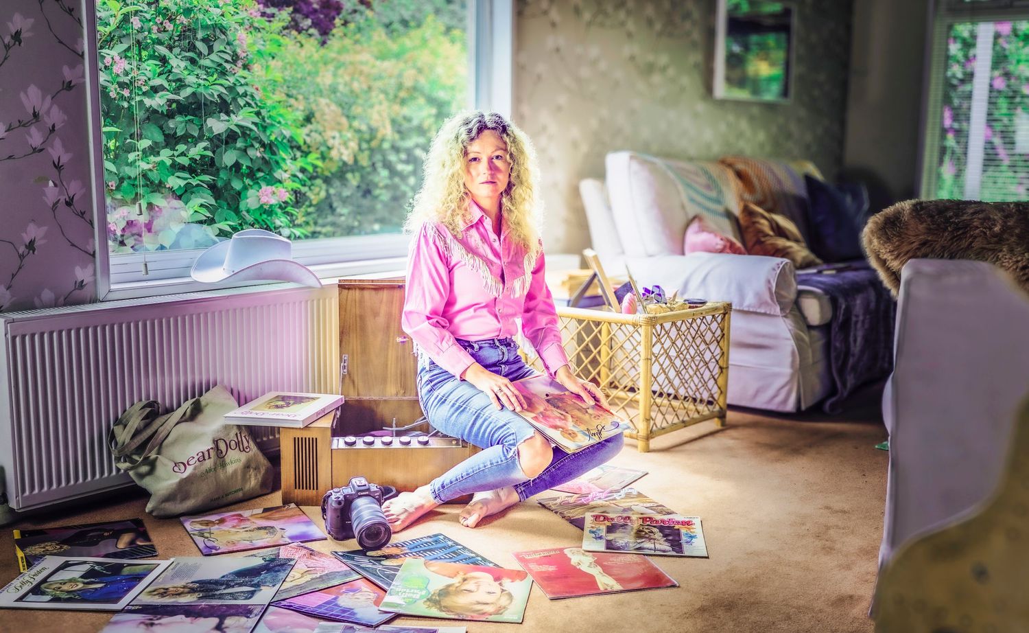 Editorial portrait of photographer Alice Hawkins surrounded by vinyl records at home, Suffolk