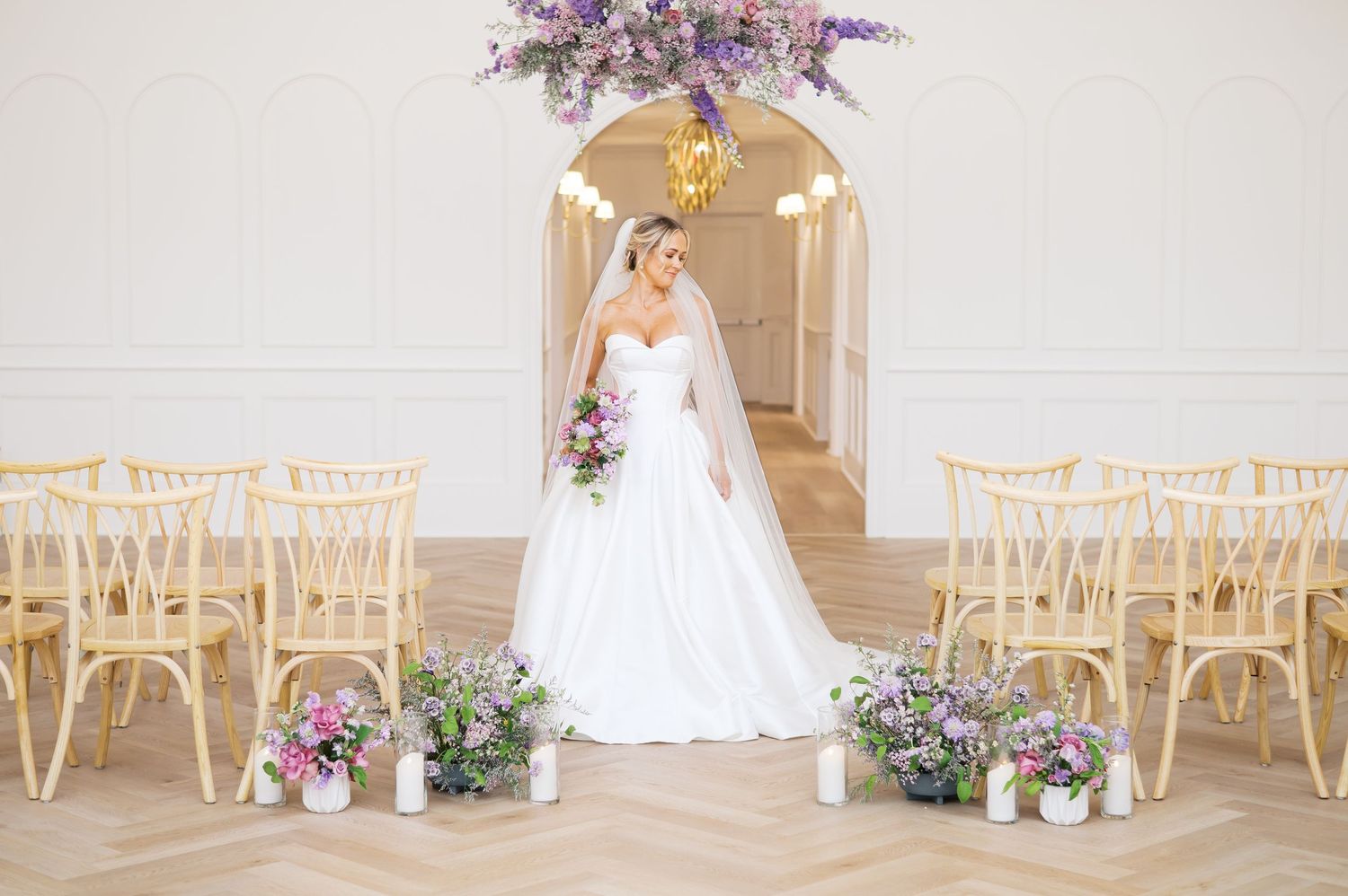 A Fayetteville NC wedding venue featuring a lavender floral color palette and a beautiful bride in a satin wedding gown