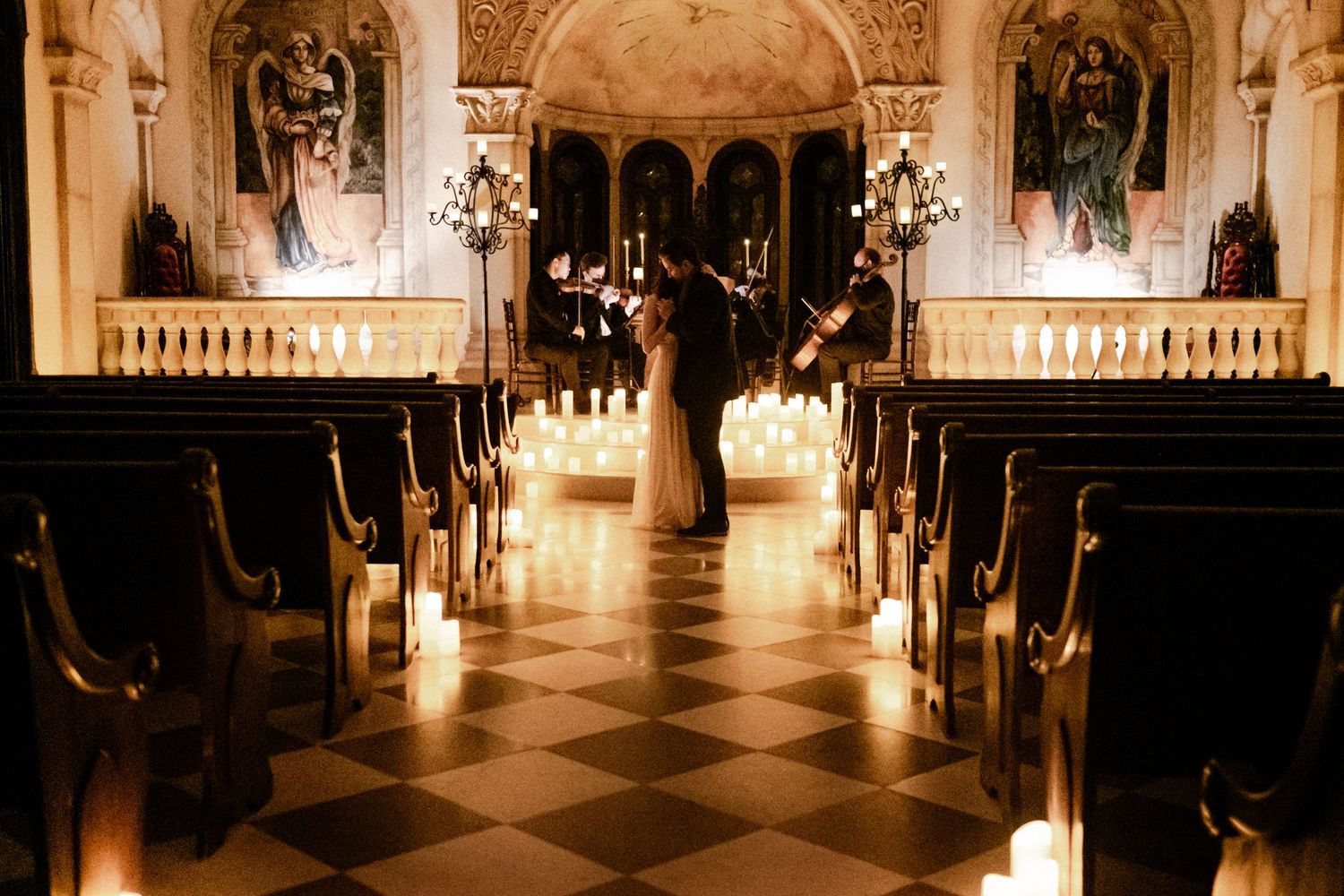 A couple dancing in a candlelit church while a string quartet performs in the moments before the man asks to marry the woman