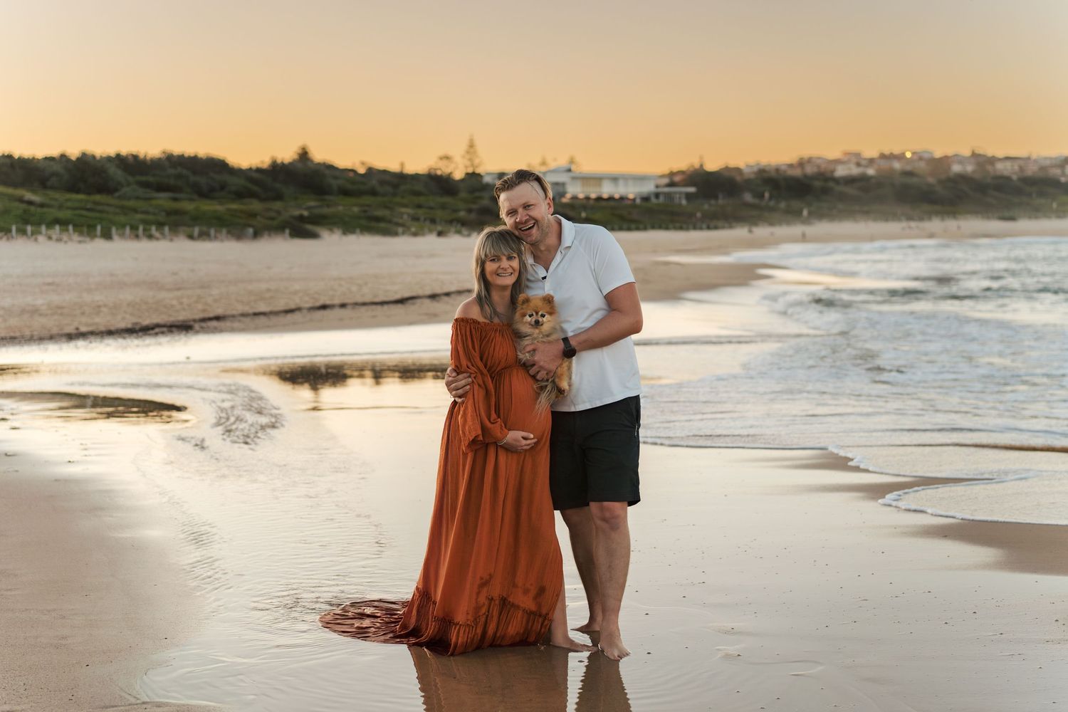 happy couple on sandy Maroubra beach in Sydney during golden sunset as waves roll onto shore in romantic coastal photoshoot