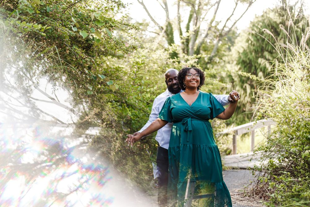 People walking together on a scenic sunlit forest trail wearing coordinated teal-colored outfits.