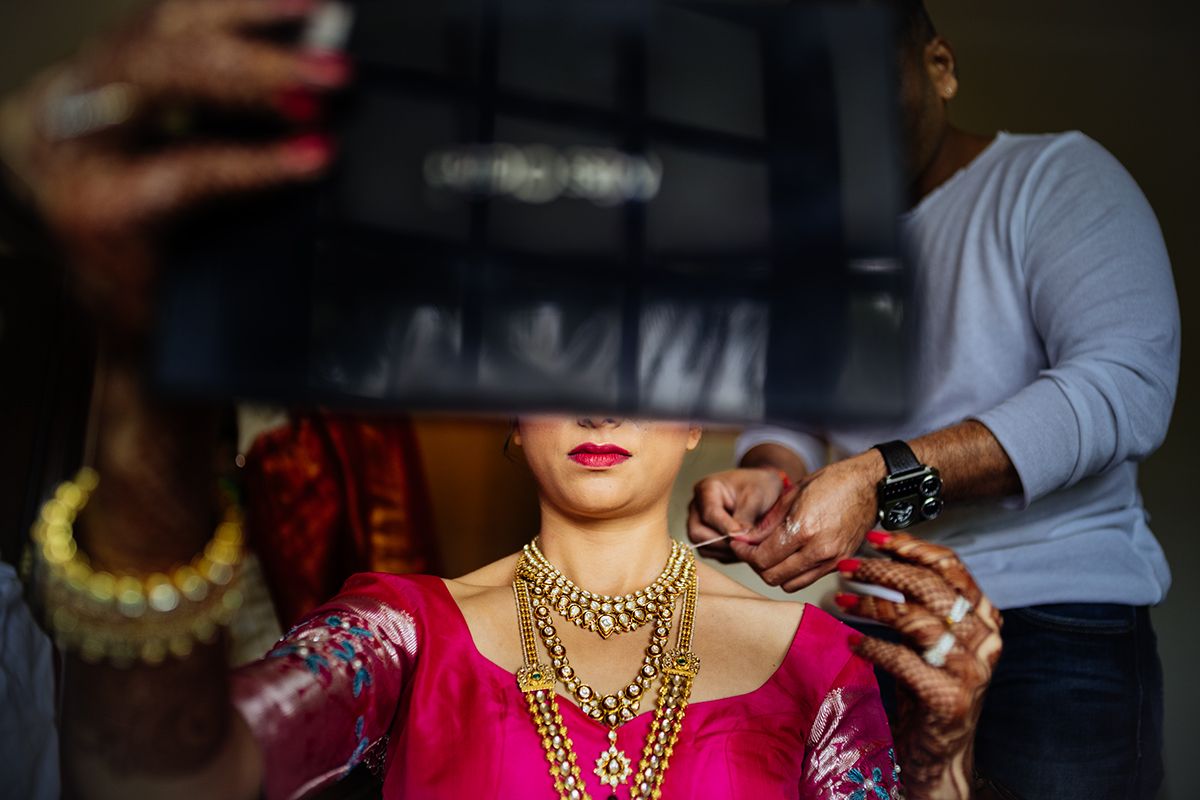 Close-up of traditional Indian bridal jewelry and makeup preparation.